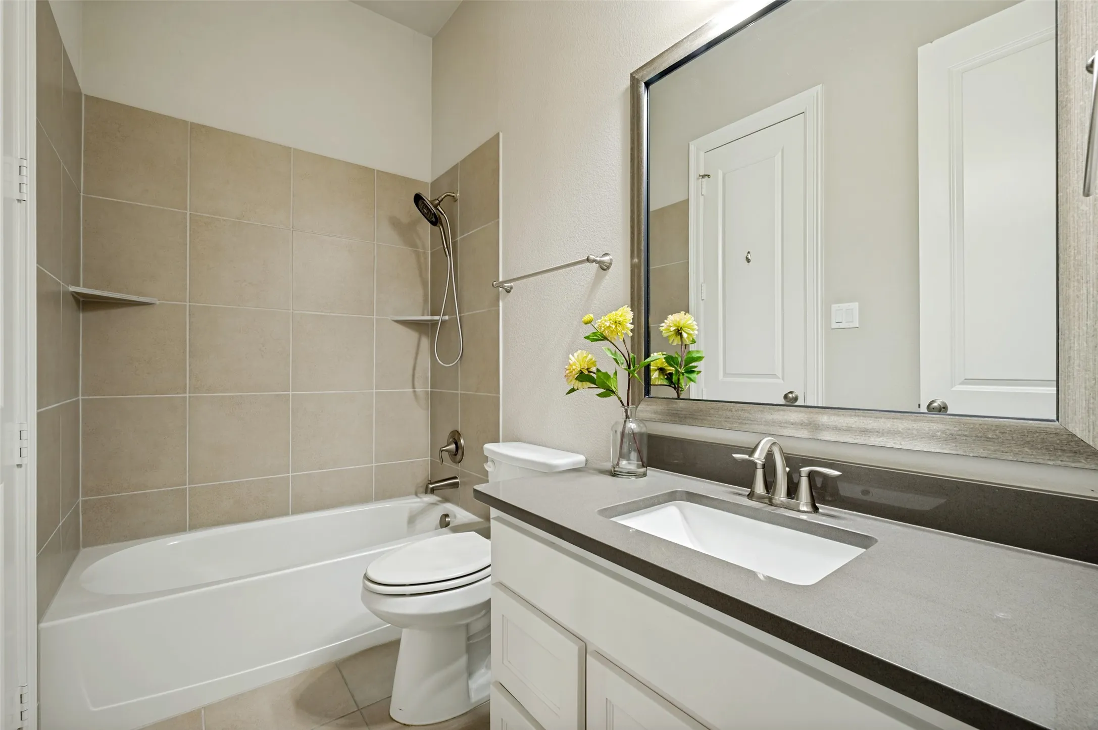 A full bath upstairs is finished with clean, timeless design, featuring a sleek vanity, quartz countertop, and a tub-shower combination with neutral tile surround. Bright, functional, and well-appointed, it comfortably serves the upstairs bedroom and additional living spaces.