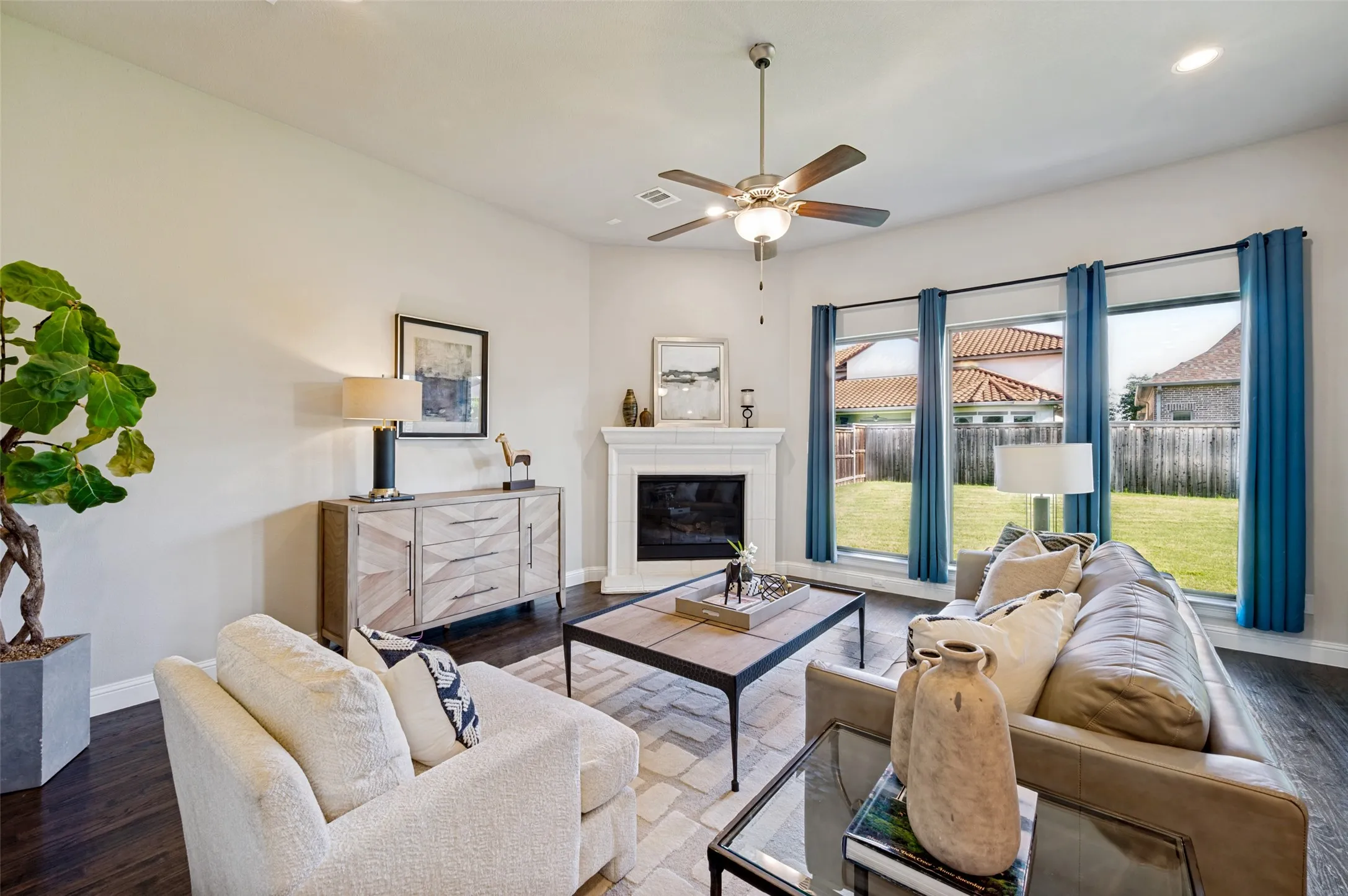 The spacious family room offers a warm and inviting retreat, where rich hardwood floors, a beautiful corner fireplace, and expansive windows create a bright, comfortable setting for everyday living. Open to the kitchen and breakfast area, this light-filled gathering space is perfectly designed for both relaxed evenings at home and effortless entertaining.