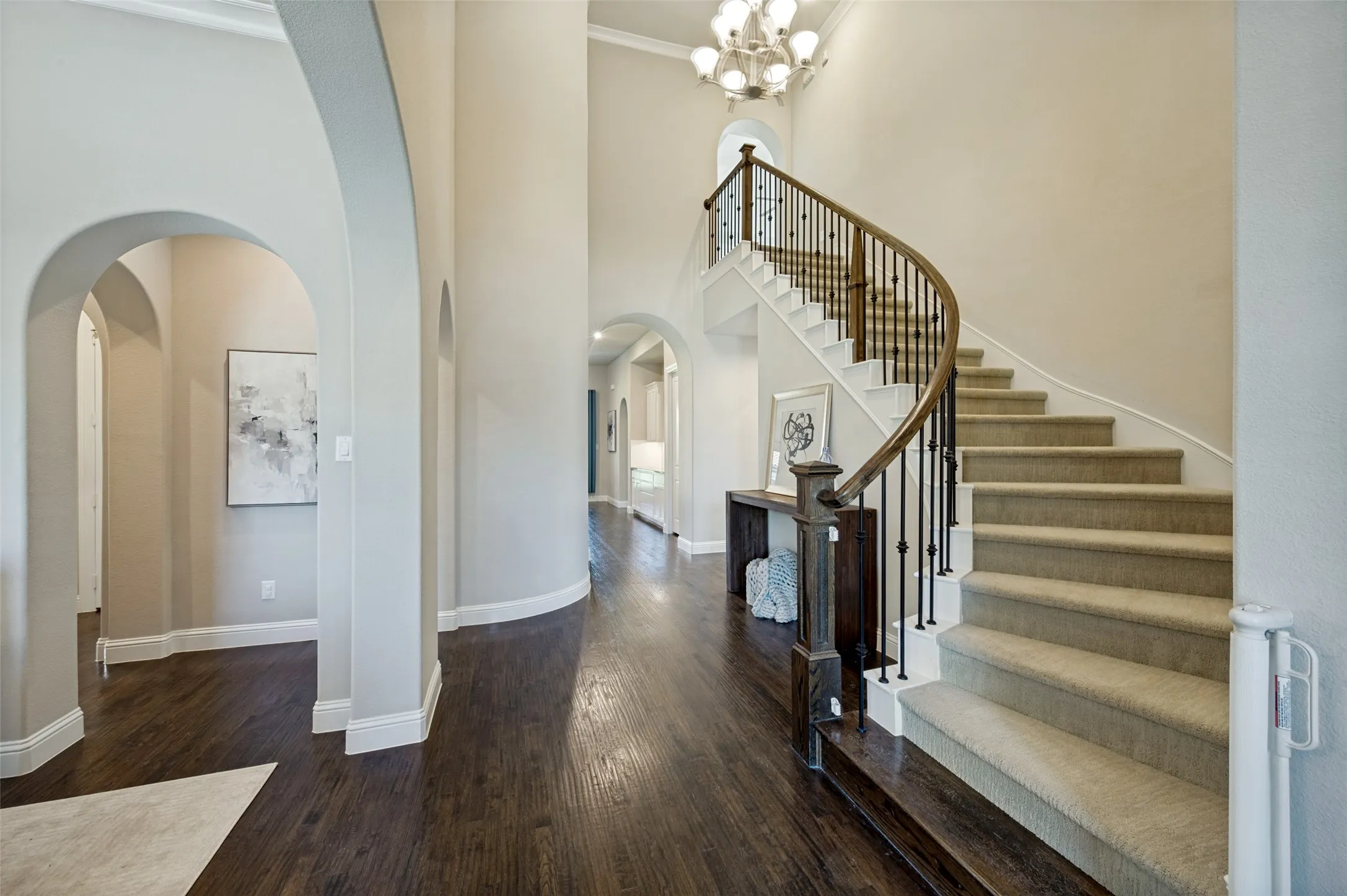 A dramatic curved staircase, soaring ceilings, and rich hardwood floors set the tone for the elegant interiors that await beyond. Framed by graceful archways and bathed in natural light, the grand foyer makes an unforgettable first impression while showcasing the timeless craftsmanship and sophisticated design found throughout the home.