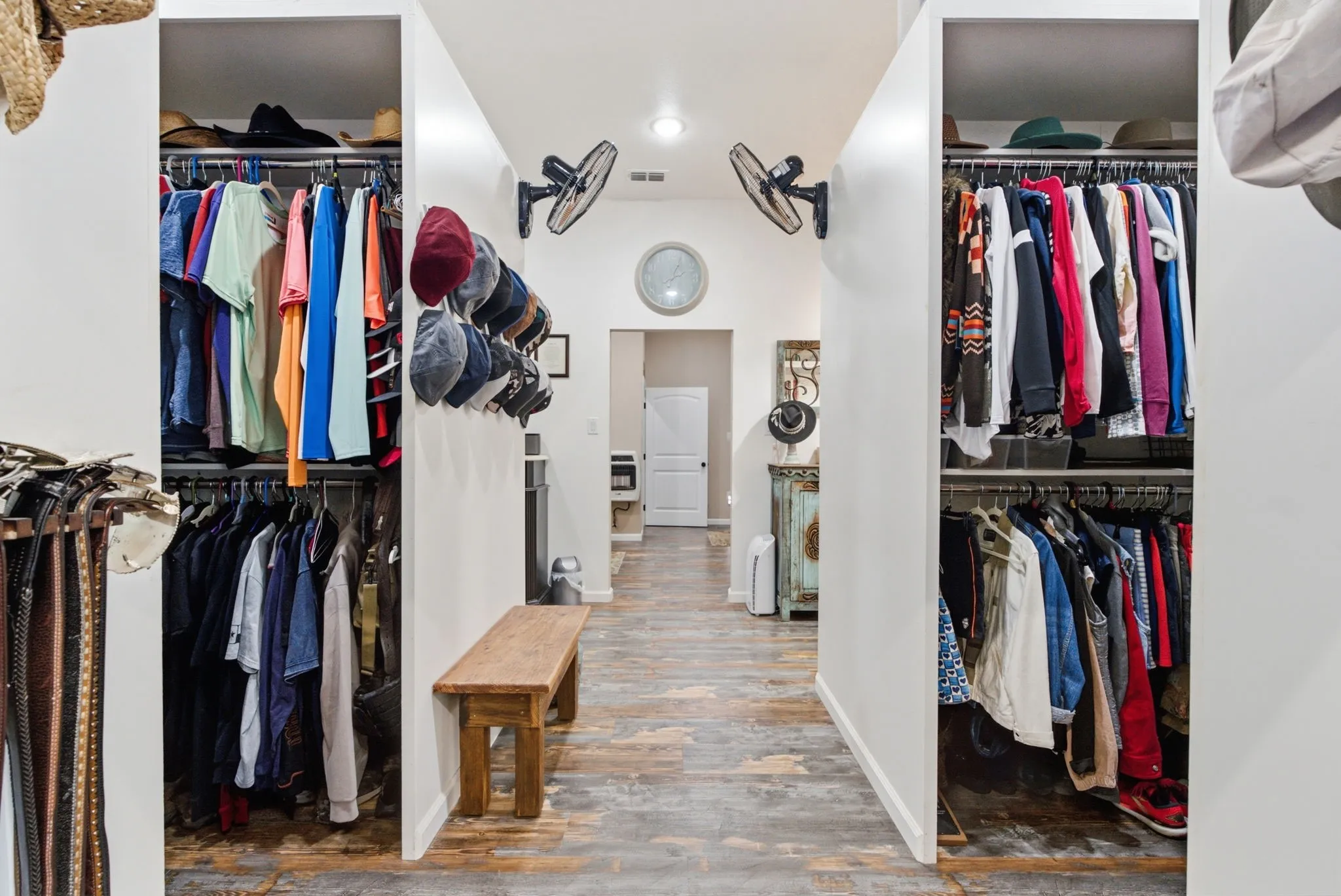 Hallway featuring wood-finish flooring, recessed lighting, and dual built-in closet spaces with shelving and hanging rods