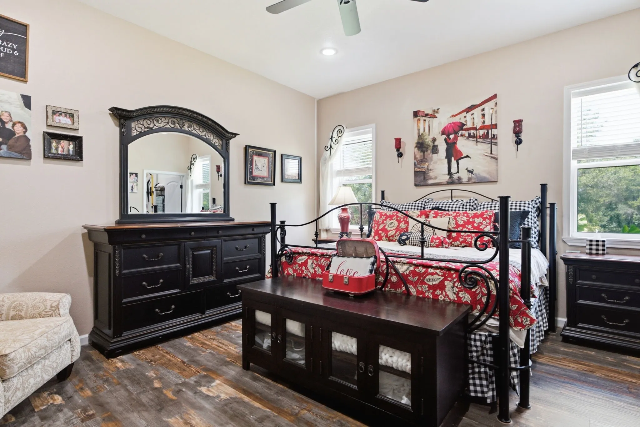 Wood-finish flooring, ceiling fan, and multiple windows with blinds