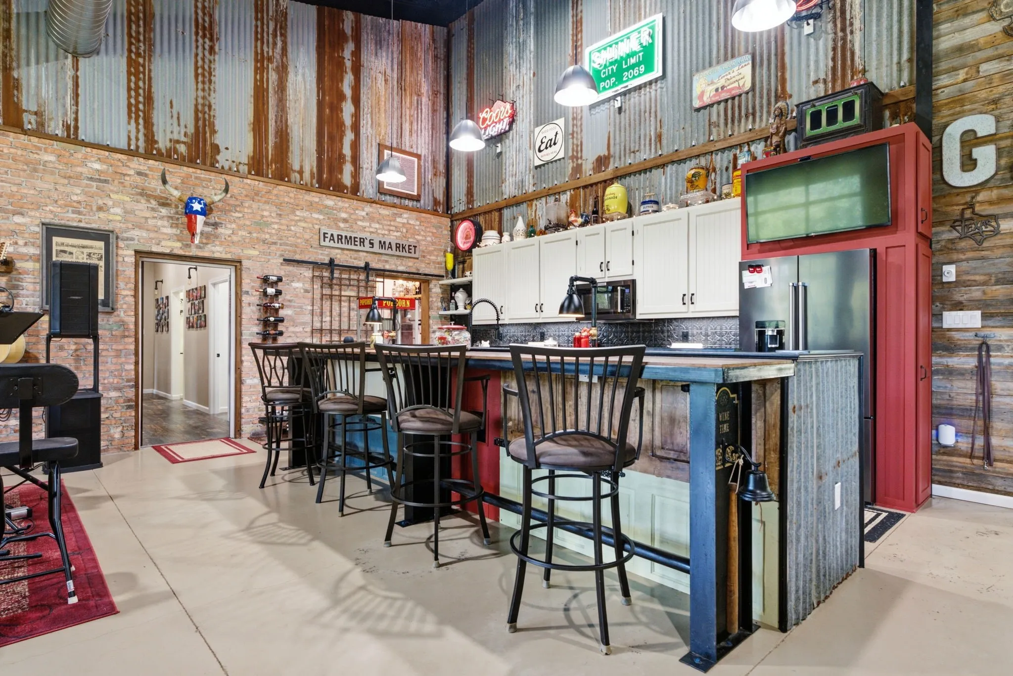Exposed brick walls, corrugated metal wall accents, and an open-concept kitchen with white cabinetry