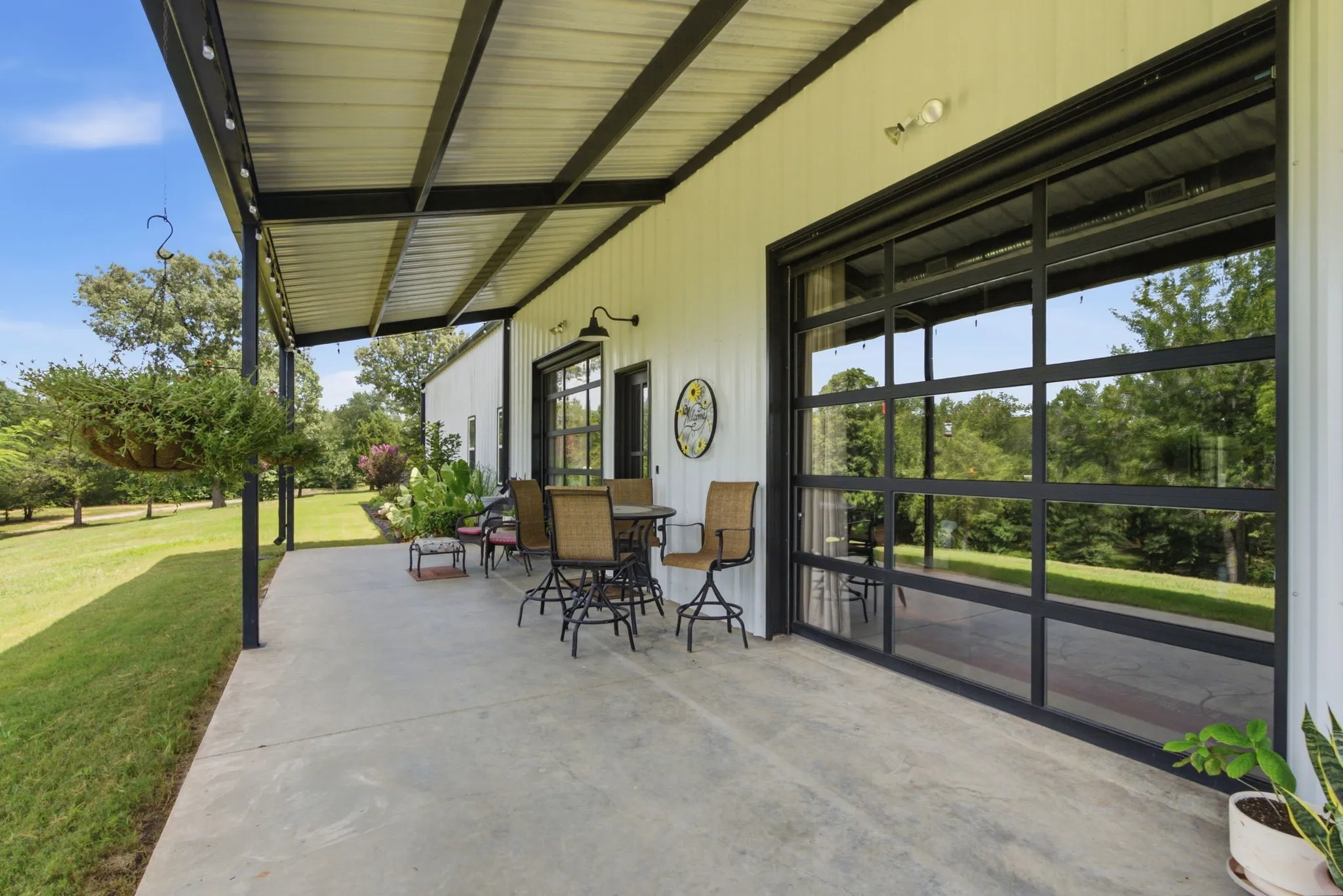 Expansive green lawn with scattered mature trees and natural landscaping
