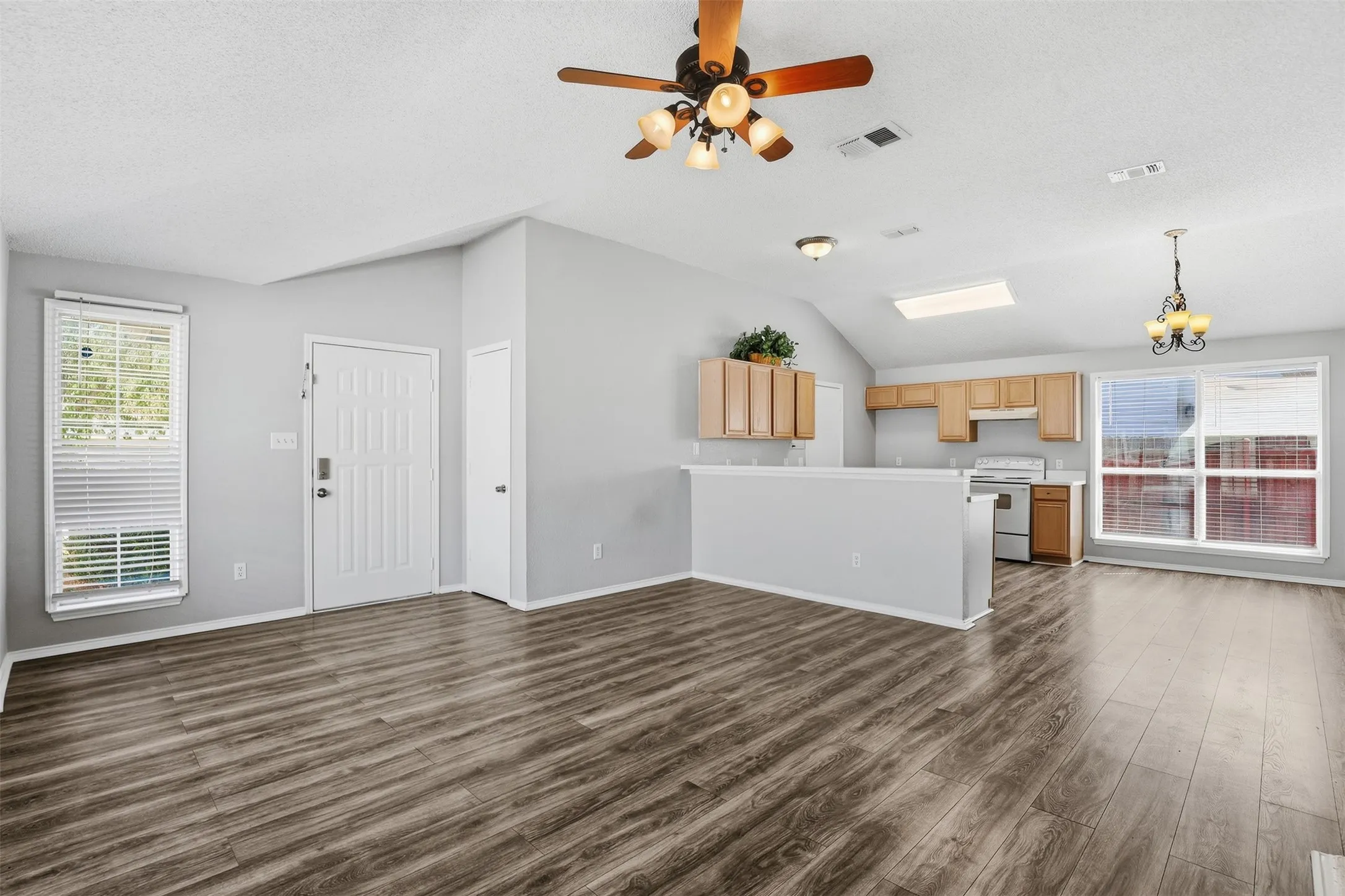 Wood-finish flooring throughout, vaulted ceiling, and recessed lighting