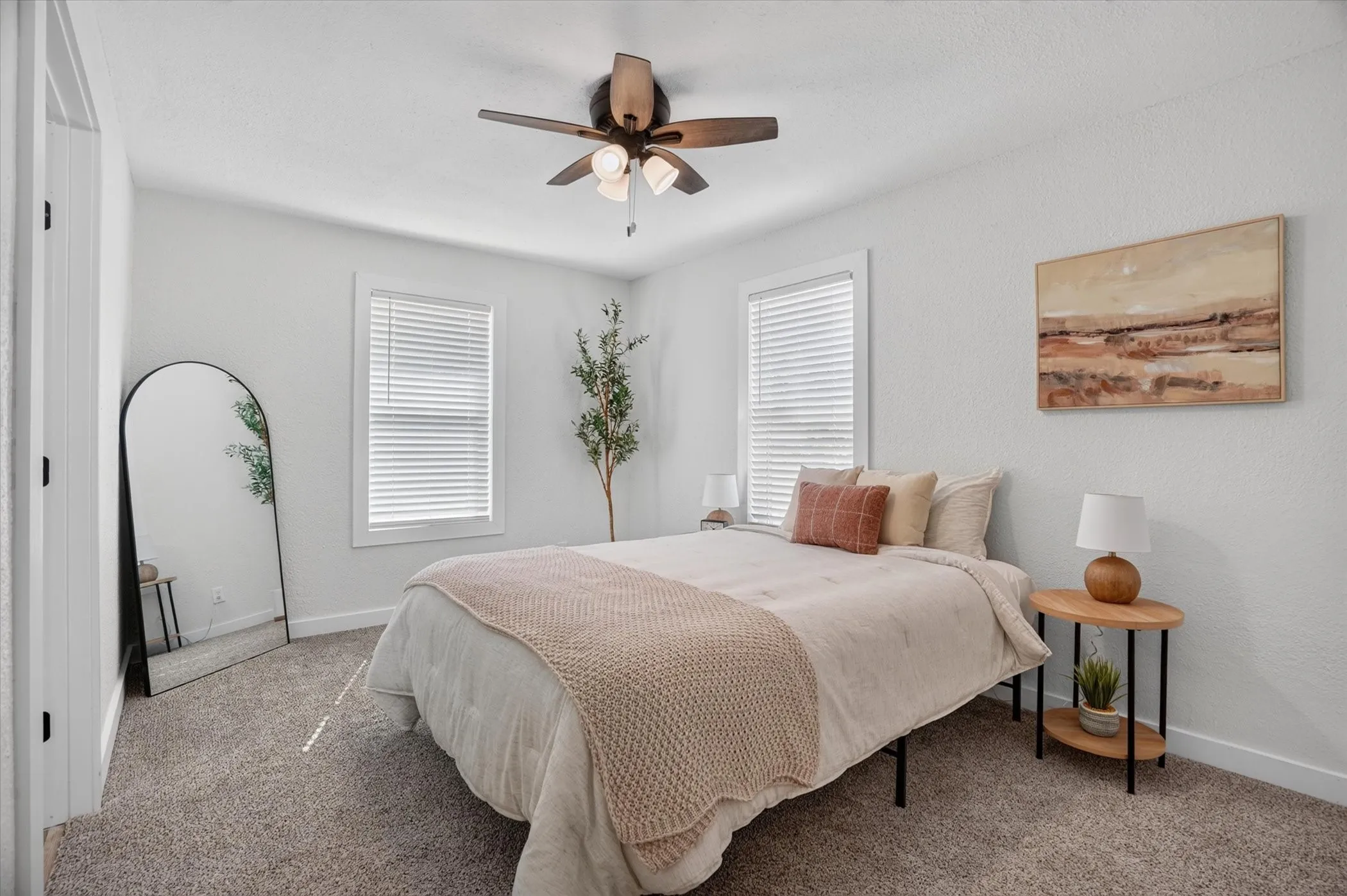 Recessed lighting, ceiling fan with wood-finish blades, two windows with blinds, and neutral carpeting