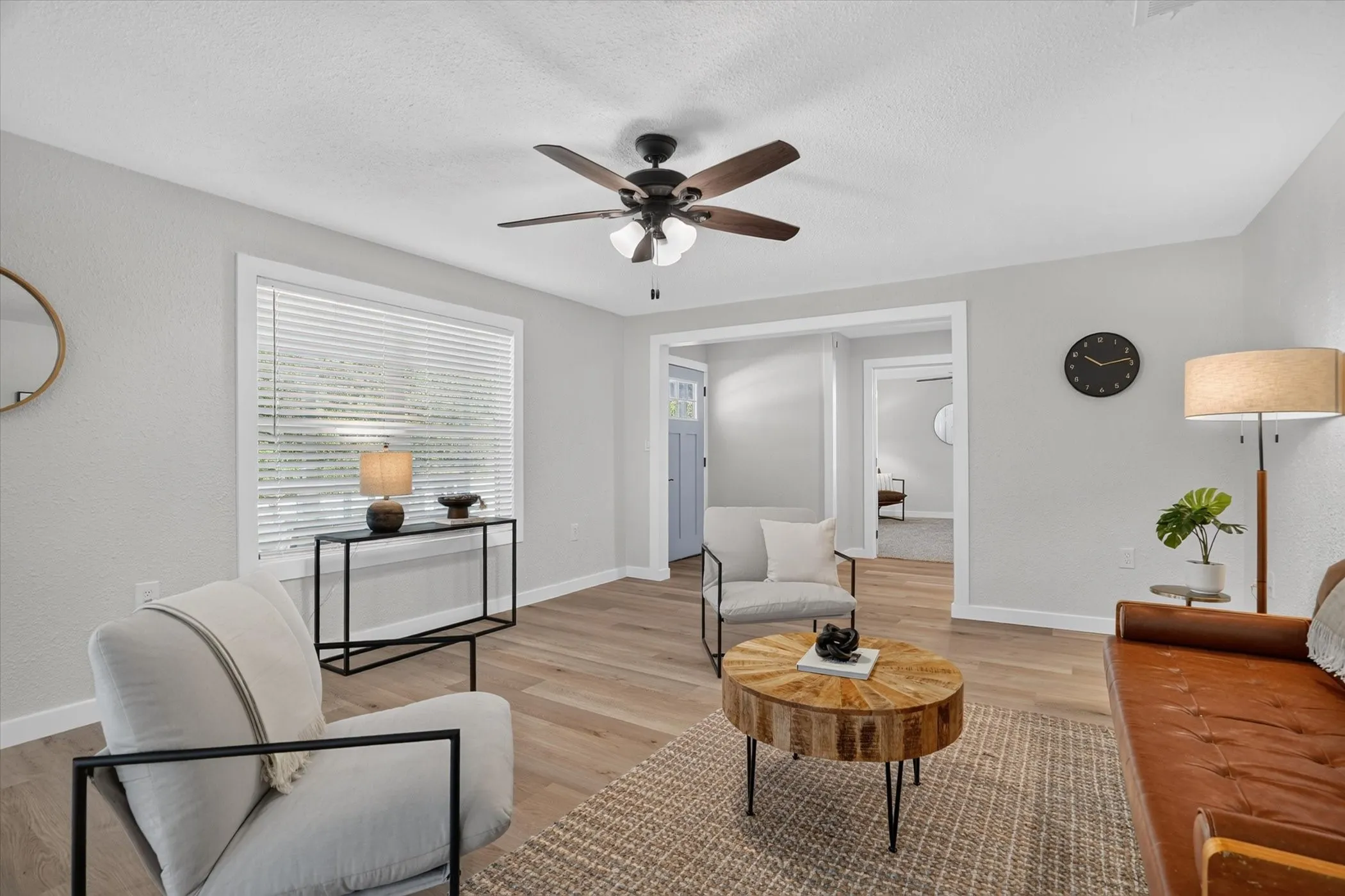 Light-toned wood-finish flooring, white trim, recessed lighting, and a ceiling fan with integrated lighting