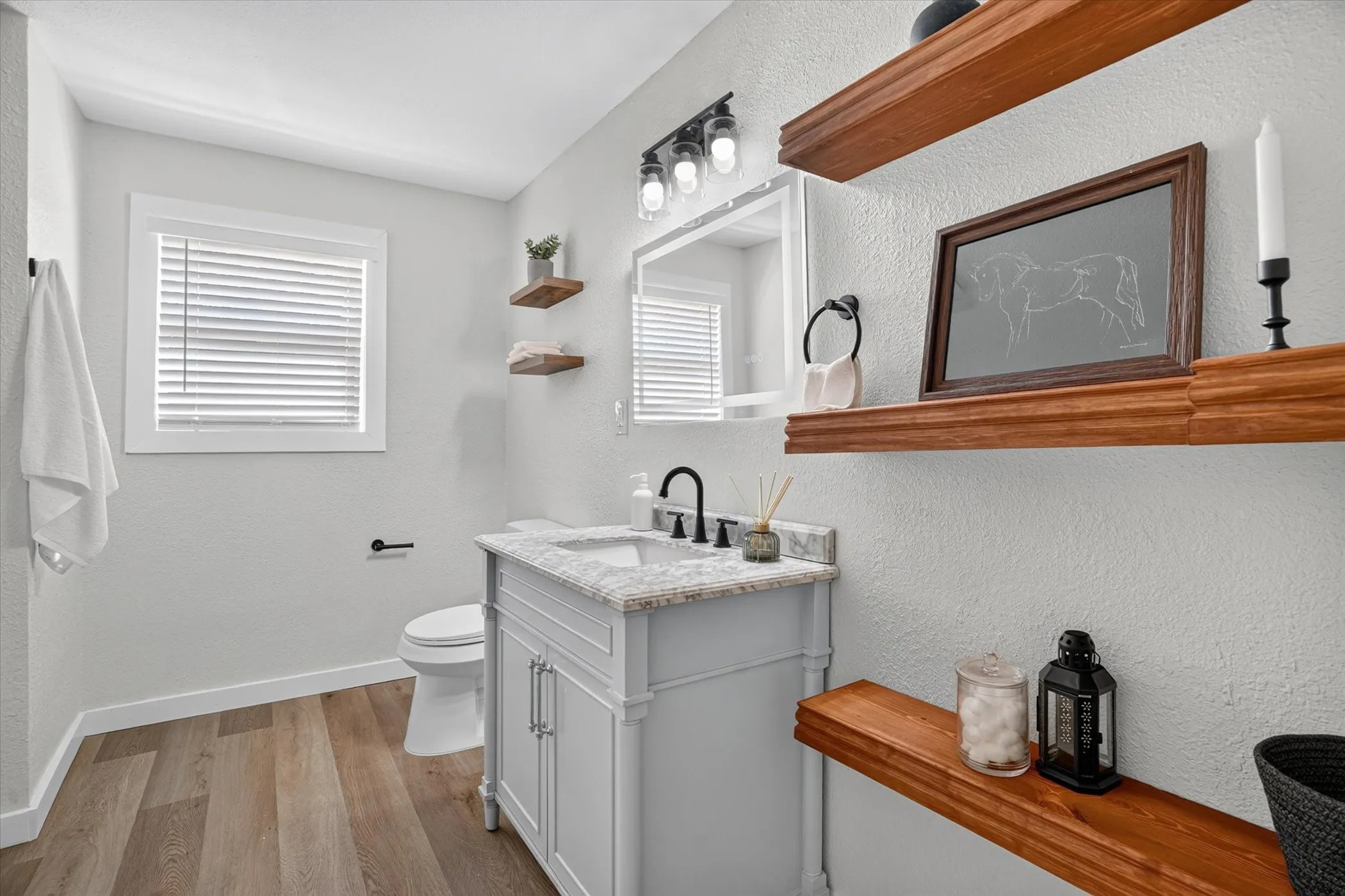 Vanity with a granite countertop, undermount sink, and matte black faucet