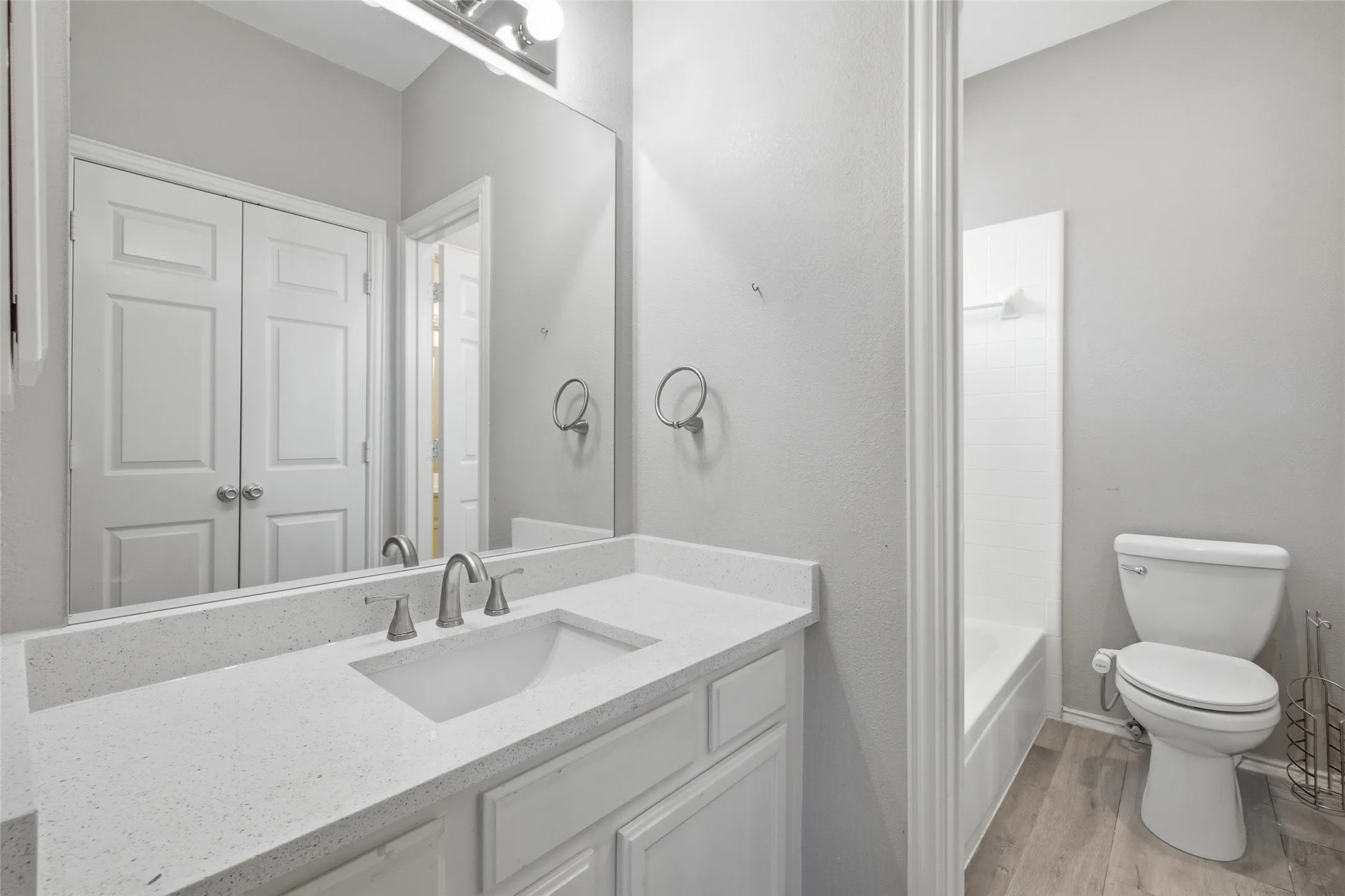 The Jack and Jill bathroom features a white quartz vanity countertop, undermount sink, brushed nickel hardware, and a tub/shower combo — providing plenty of options for a multi-bedroom upper level.
