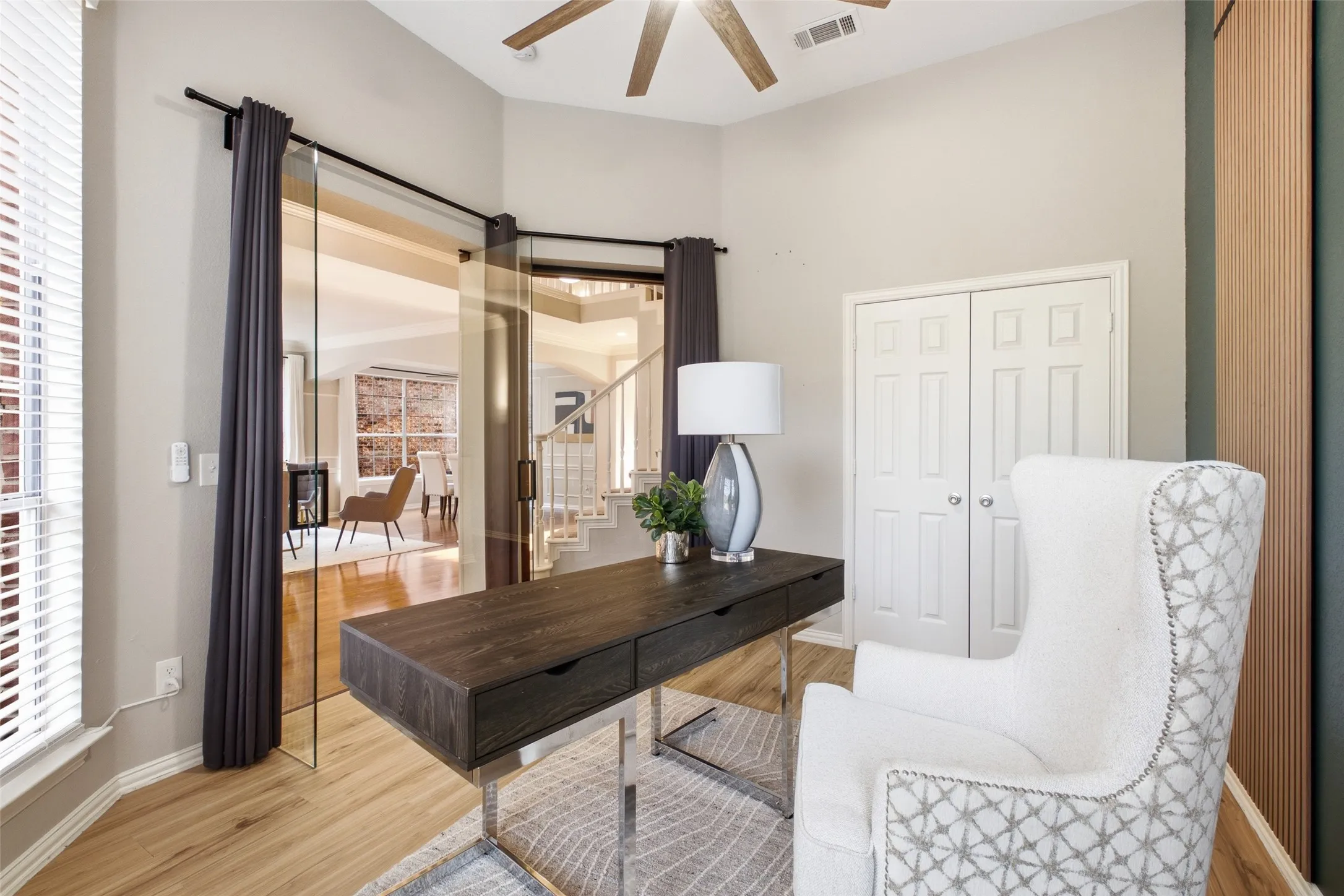 The glass sliding barn door is both a design feature and a practical privacy solution for the home office — letting light in while keeping sound out. A ceiling fan, closet, and bay window make this one of the most functional first-floor offices you'll find.