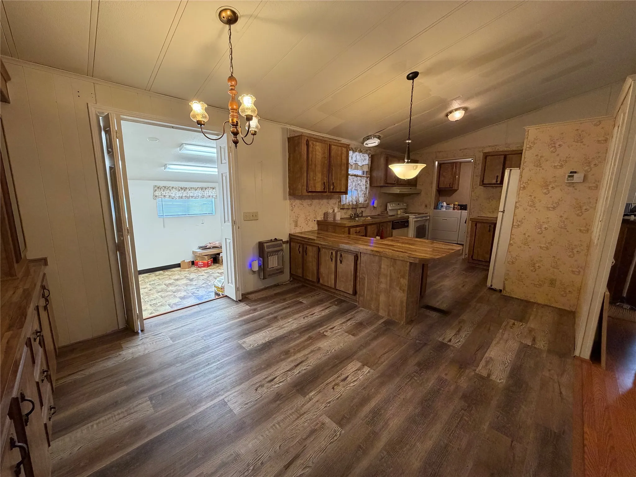Wood-finish flooring throughout, wood-finish cabinetry, built-in kitchen island, and multiple ceiling-mounted light fixtures