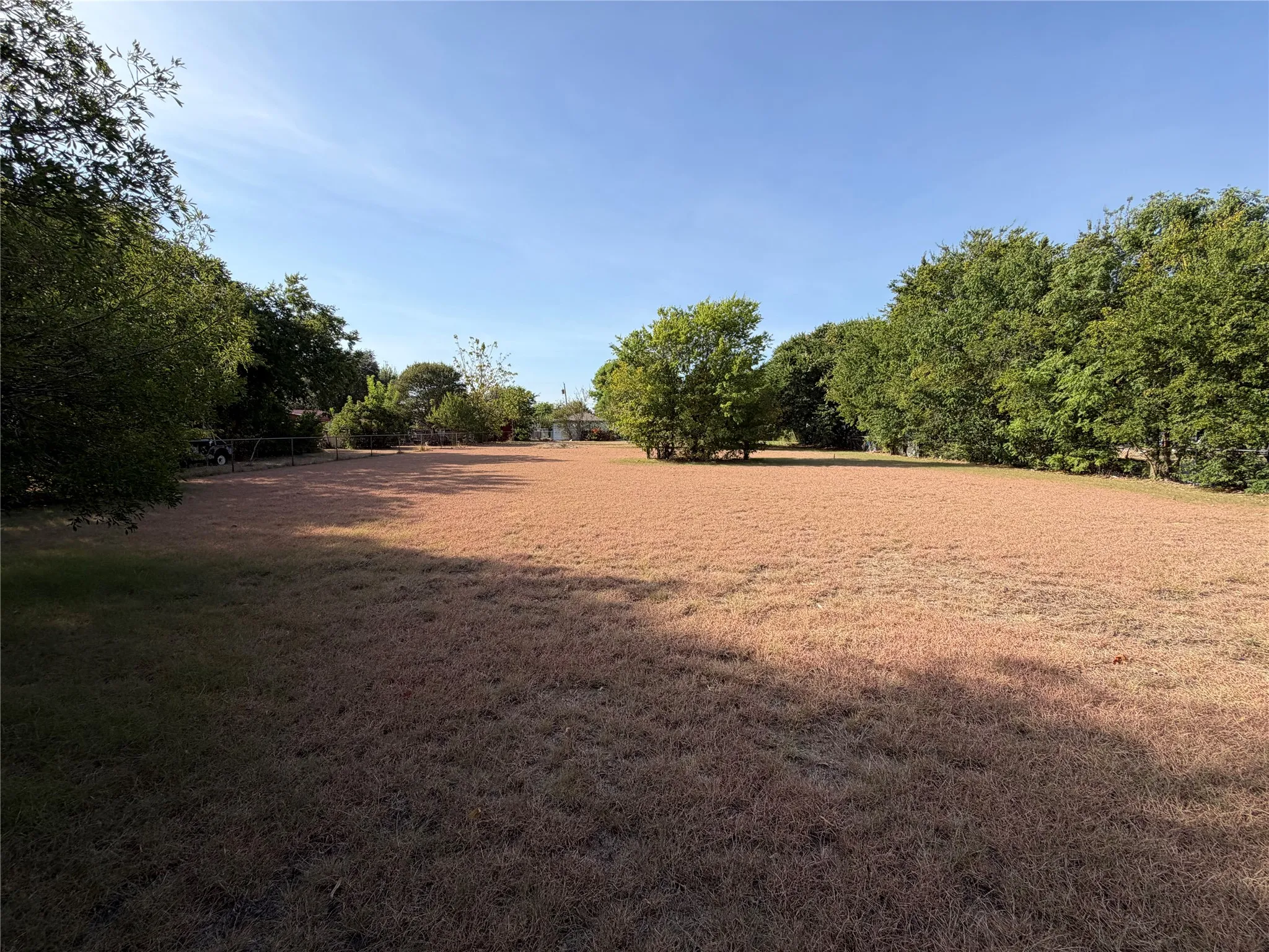 Expansive grounds featuring mature trees scattered throughout, offering natural shade and privacy