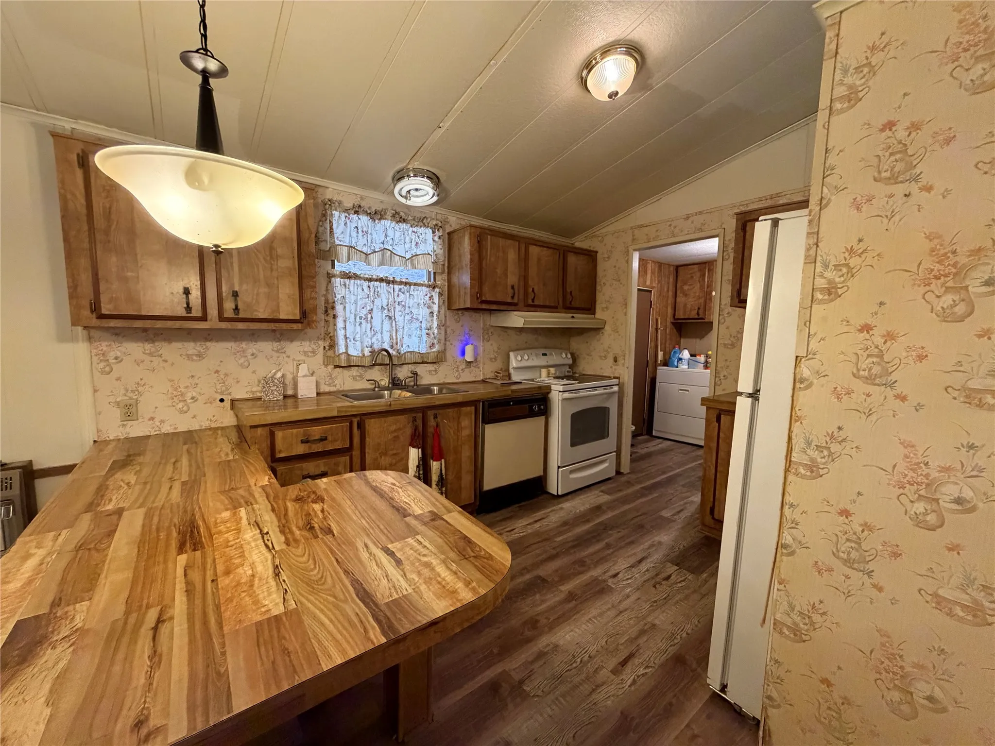 Wood-finish flooring, wood cabinetry, and a U-shaped countertop
