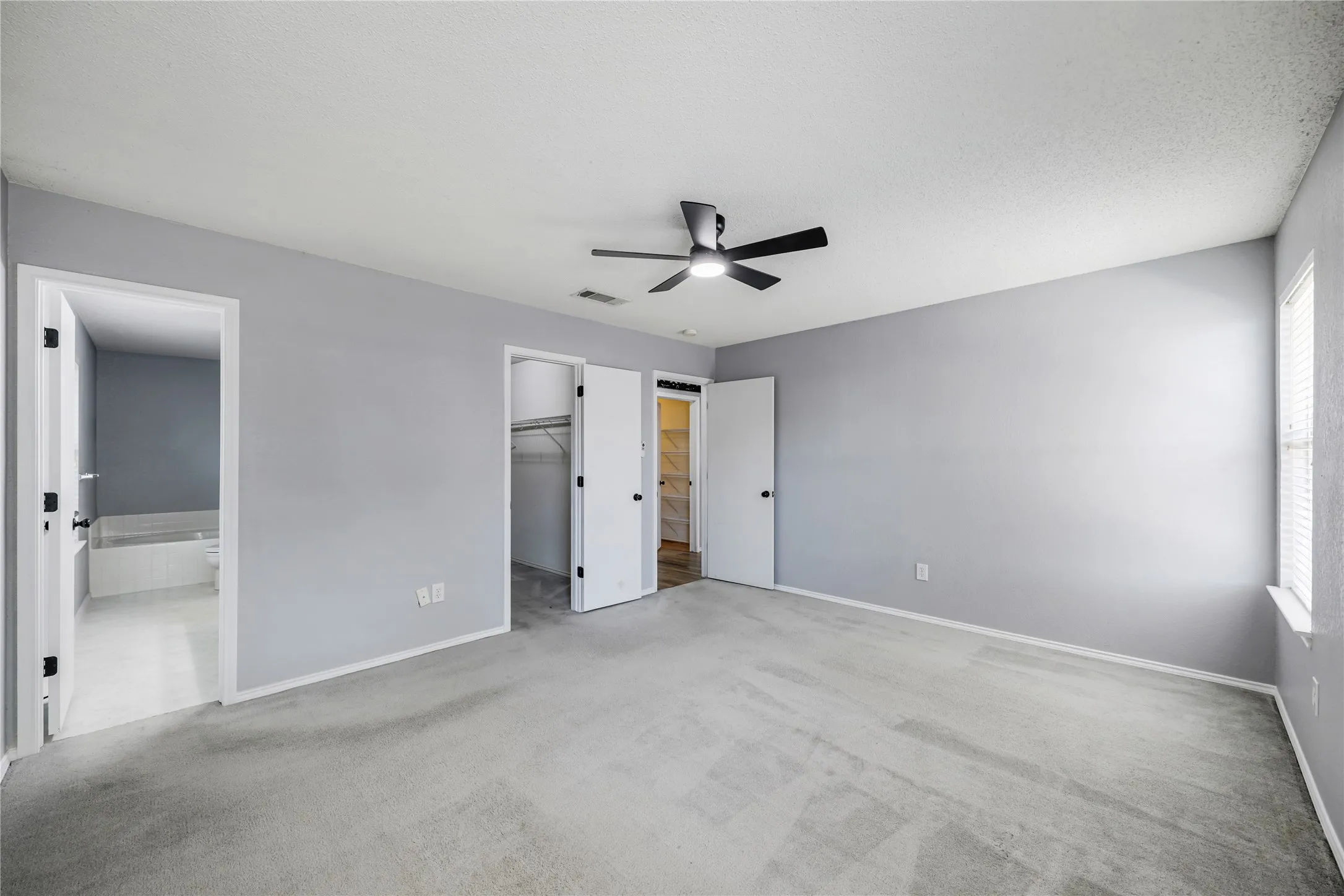 This view of great wall space and the entry into the ensuite bathroom in the primary bedroom