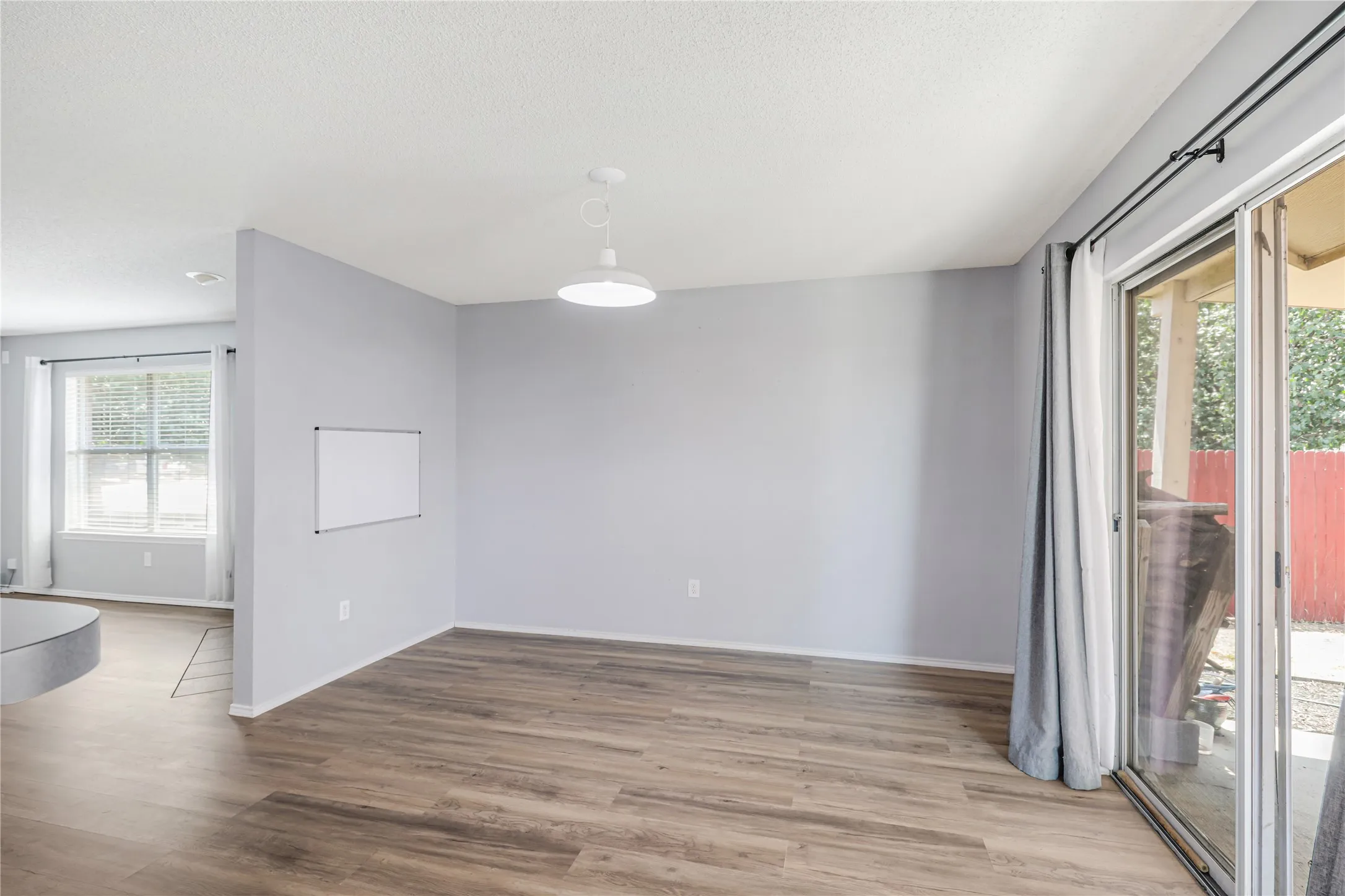 This view of dining room has lots of natural lighting from the sliding glass door and flows into the living room