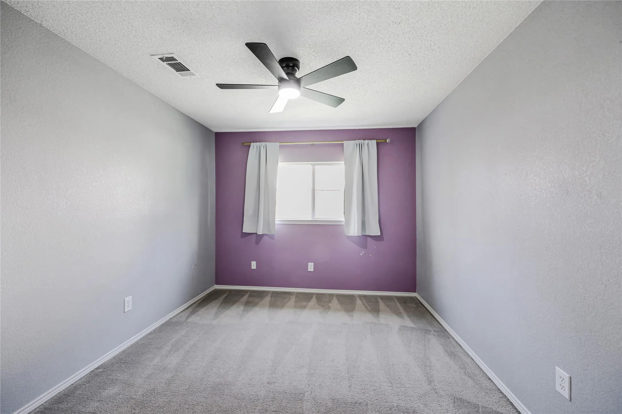 Secondary split bedroom with accent wall, ceiling fan wiht light