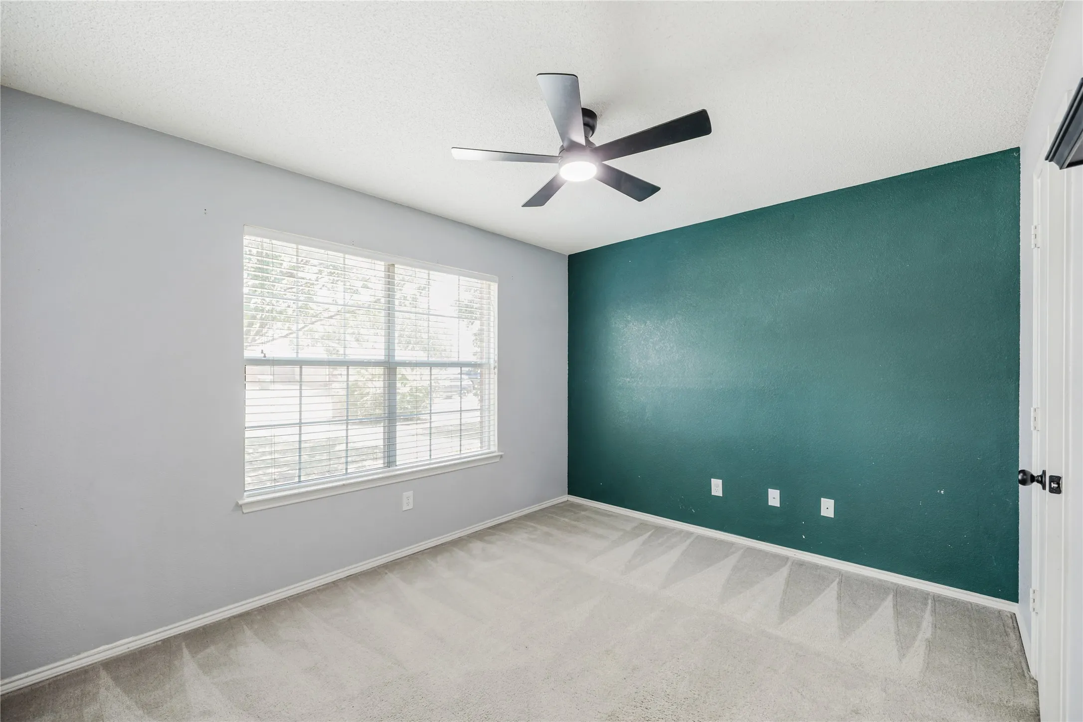 Front bedroom with new modern ceiling fan and a large walk-in closet
