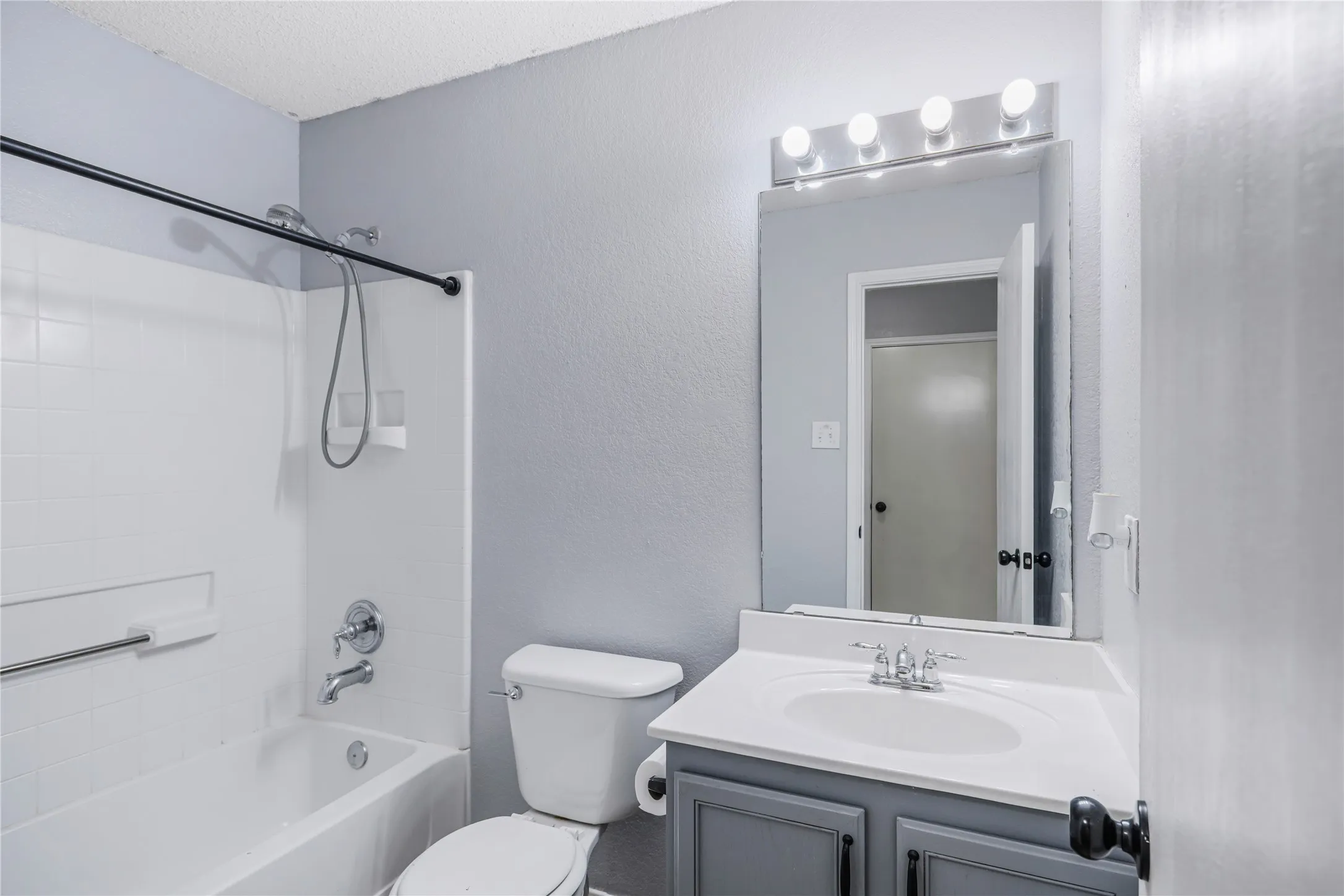 This secondary bathroom with a single sink and modern lighting and laminate flooring.