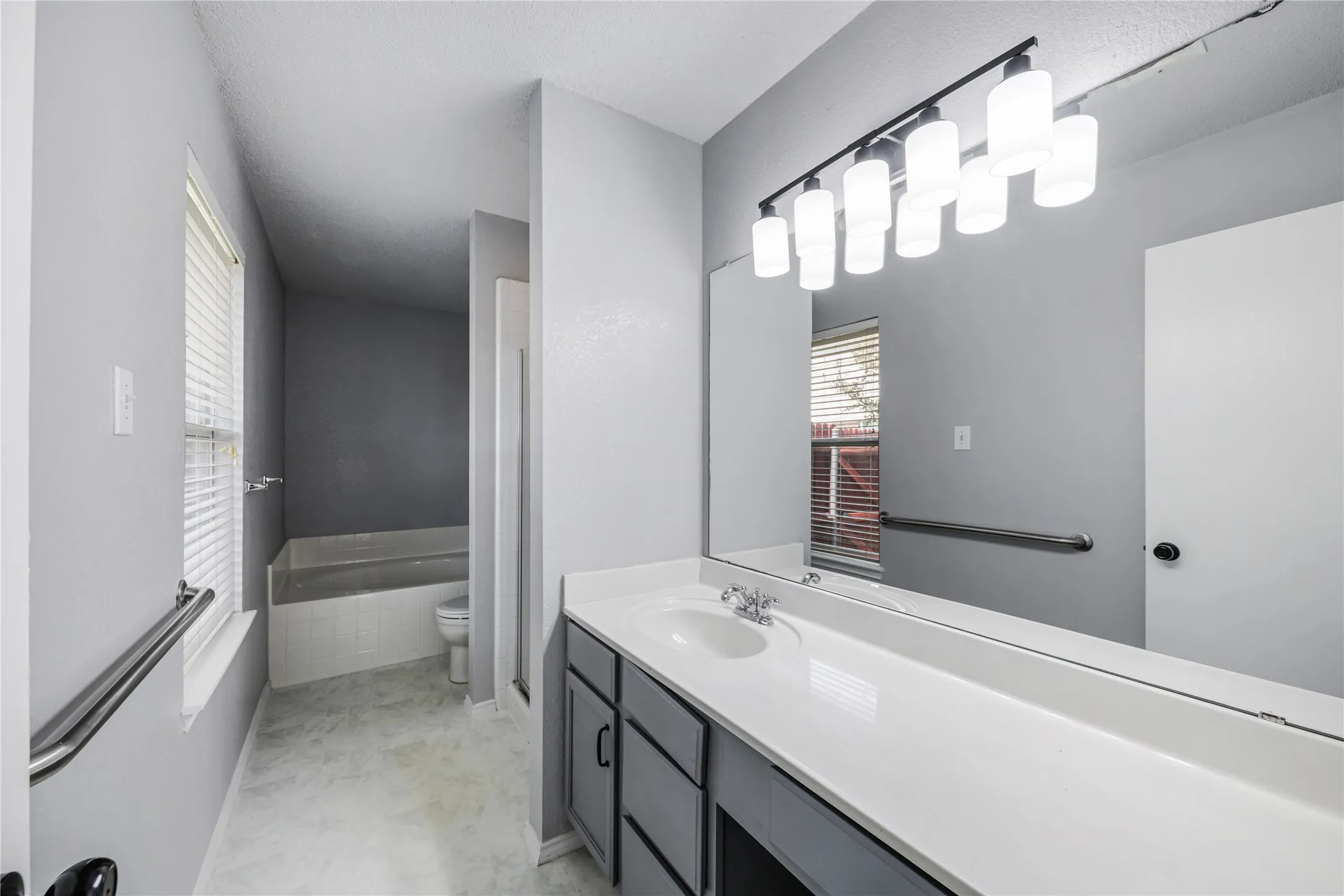 This primary ensuite bathroom features great counter space and a desk for your convenience