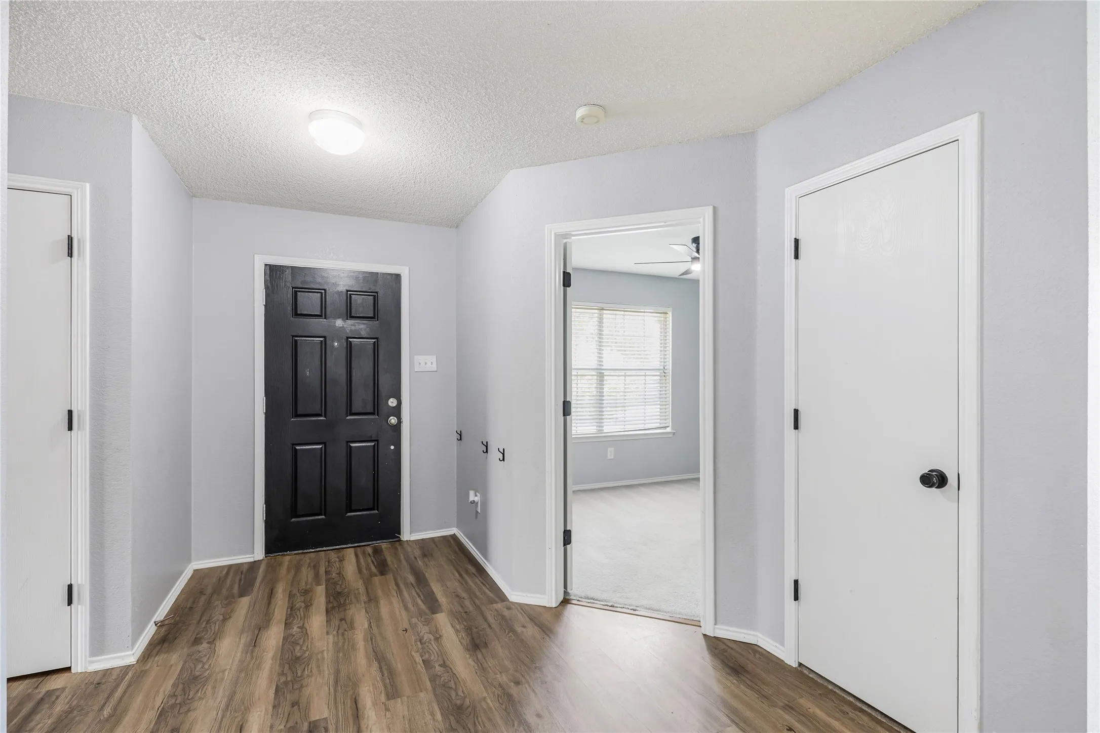 Walk into foyer featuring a coat closet, linen closet and entry into front bedroom.