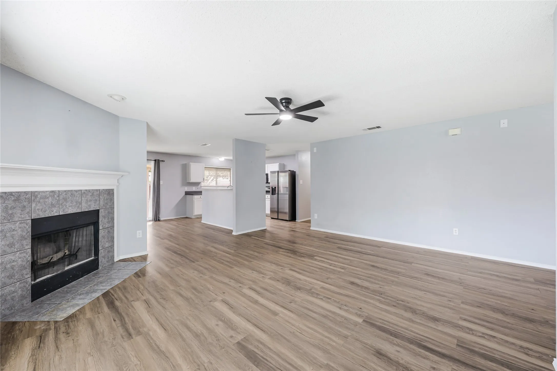 A wood burning fireplace and generous wall space in the living room for furniture placement