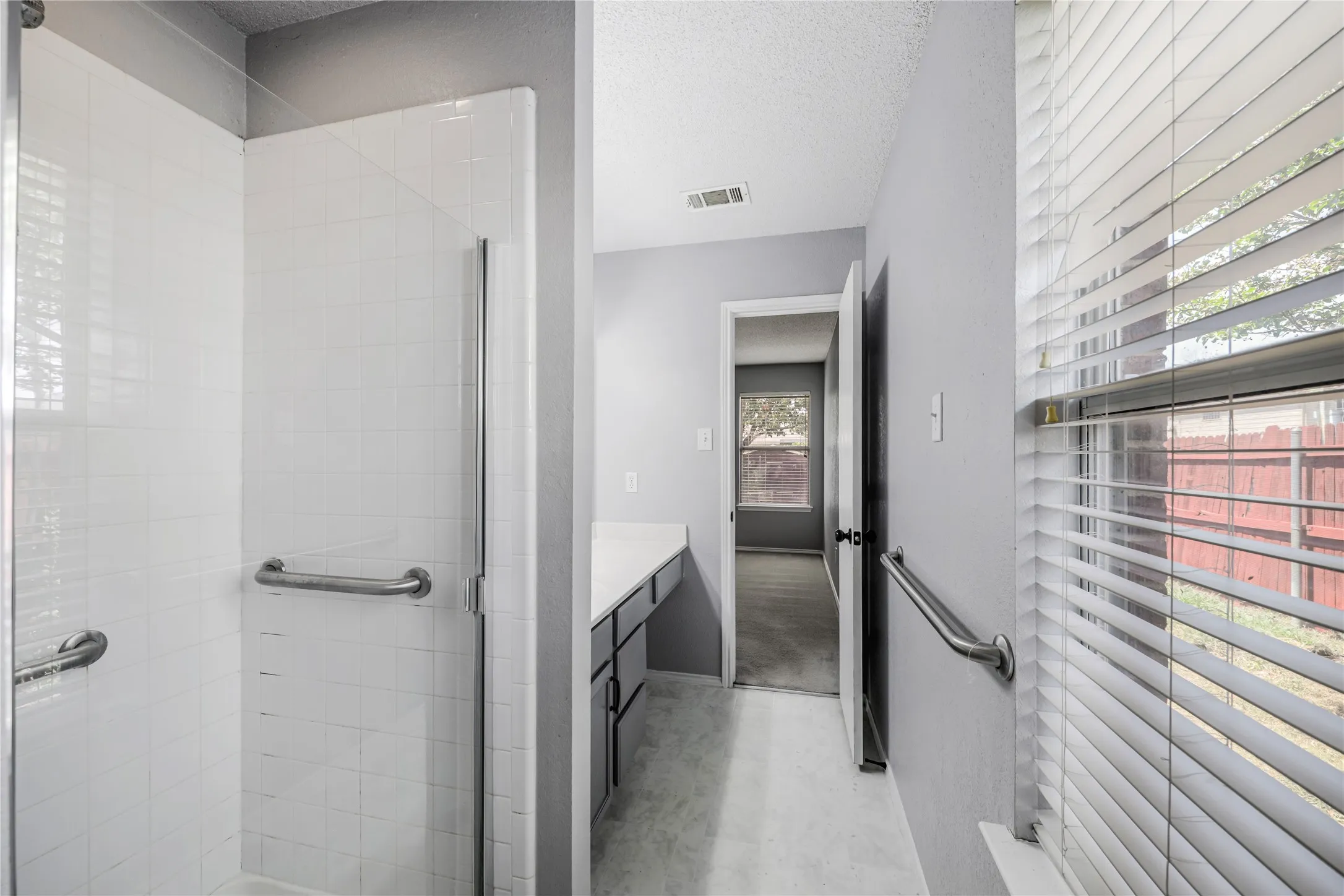 Tiled surround separate shower and a window in this ensuite primary suite