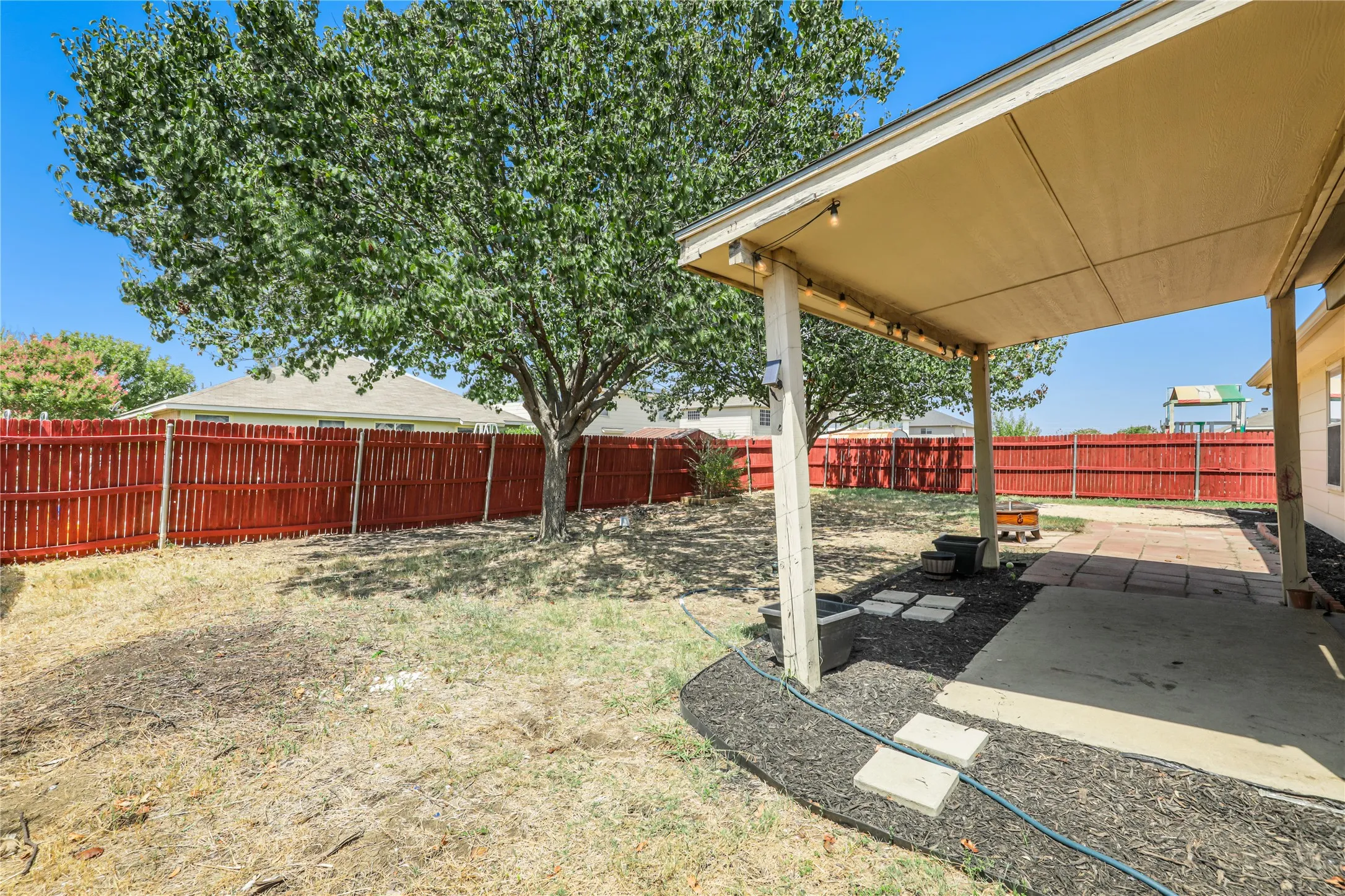 Large covered patio and fresh stained wood fence.