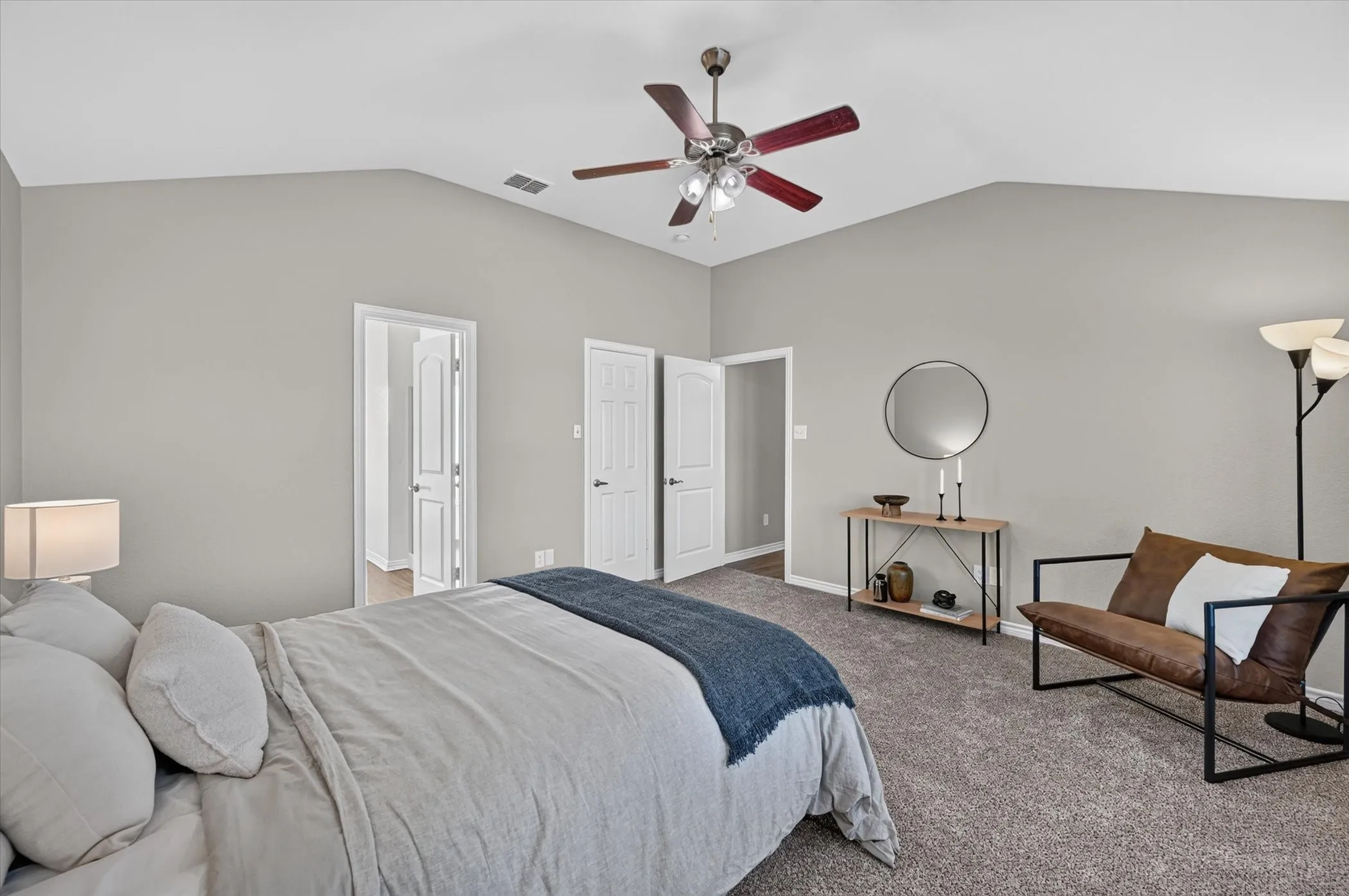 Vaulted ceiling with a ceiling fan, light gray wall paint, and gray carpet
