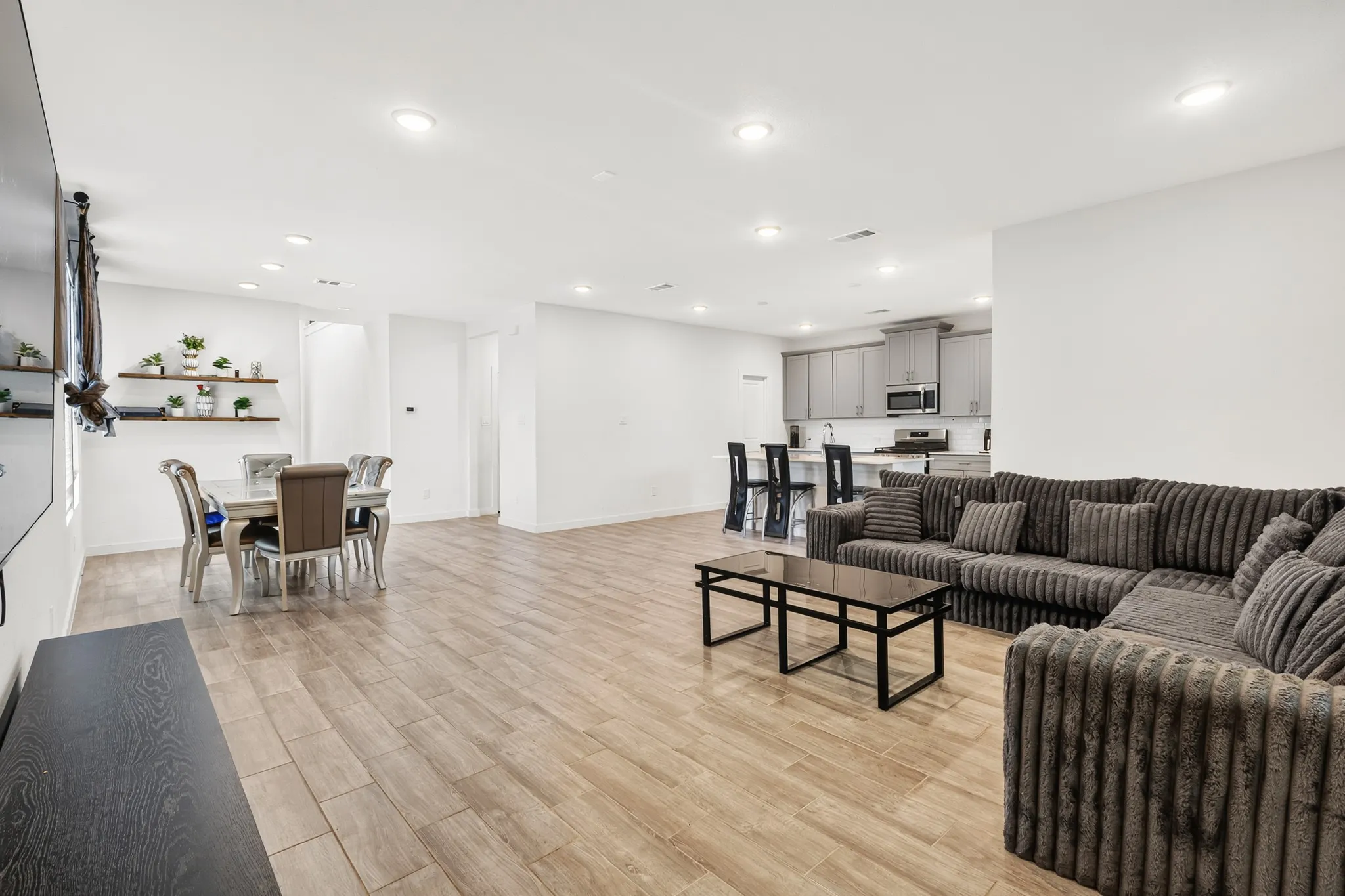 Open-concept living space featuring wood-finish flooring and recessed lighting
