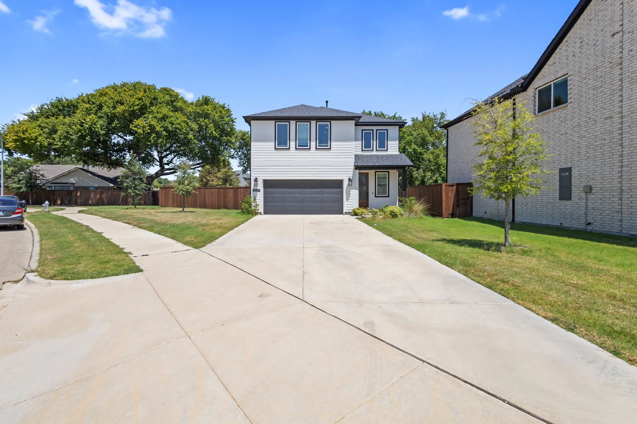 Modern two-story exterior with white siding and dark trim