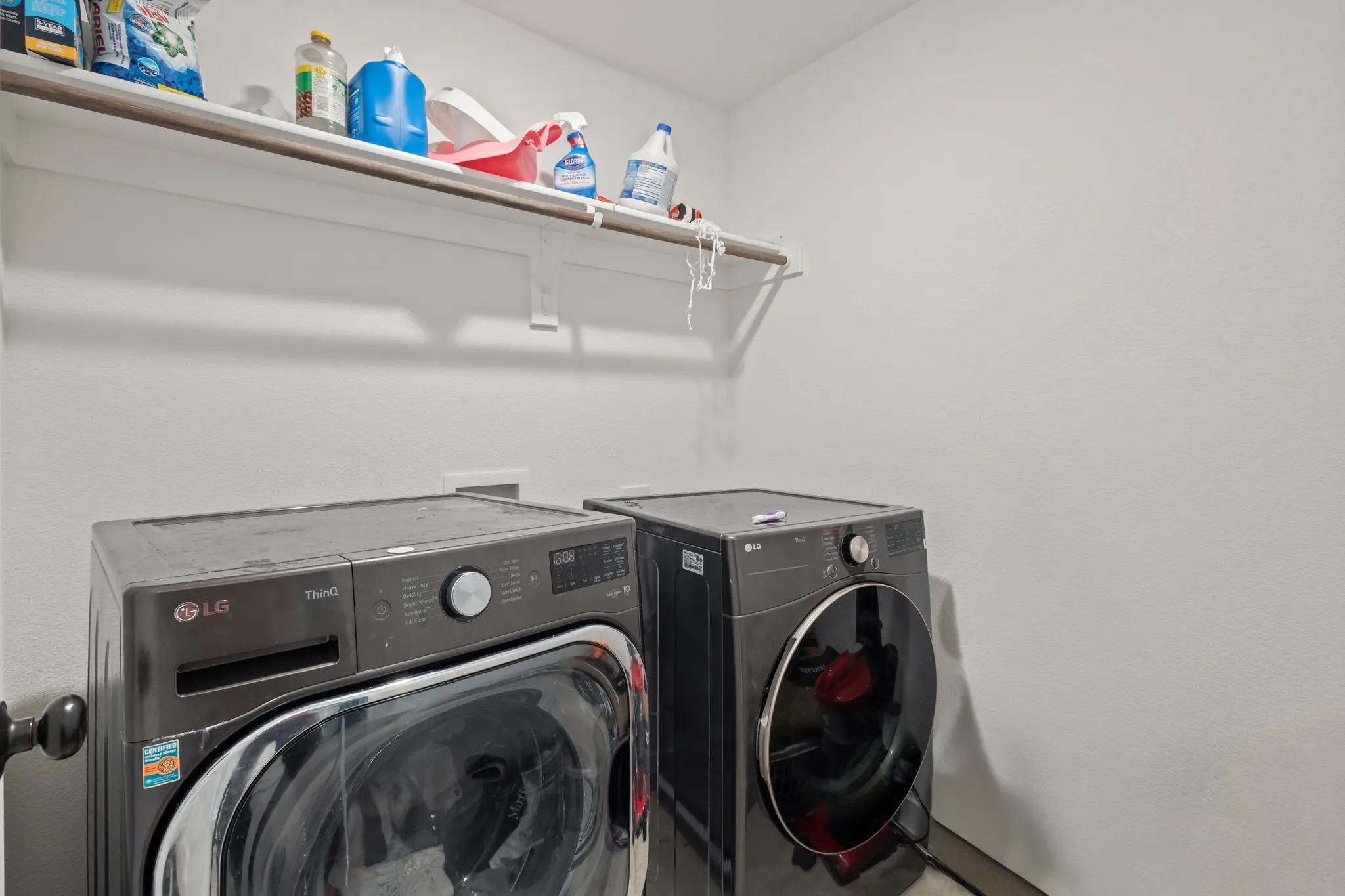 Utility area with white shelving and neutral wall tones