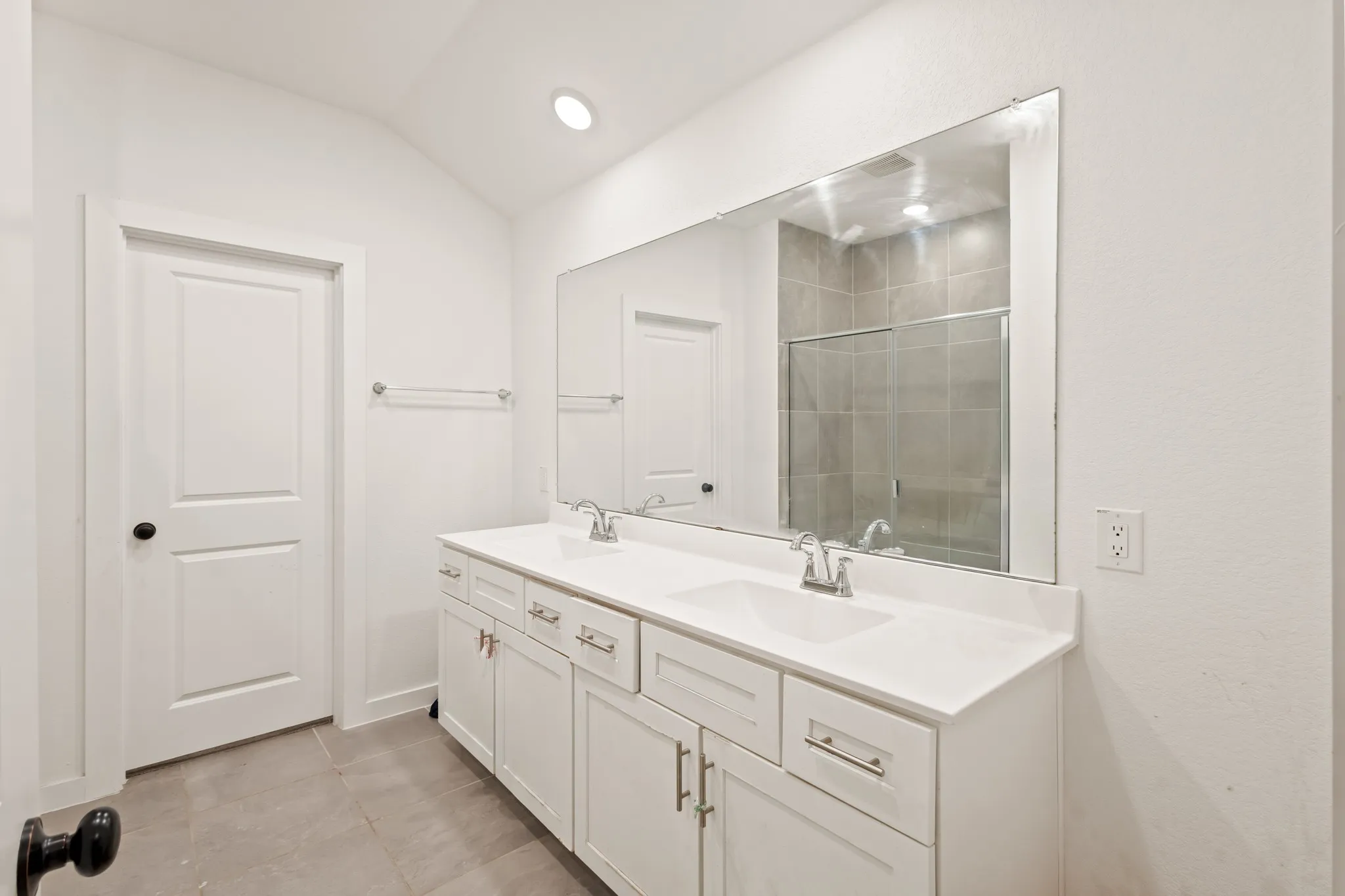 Double vanity with white cabinetry, dual undermount sinks, and polished chrome faucets