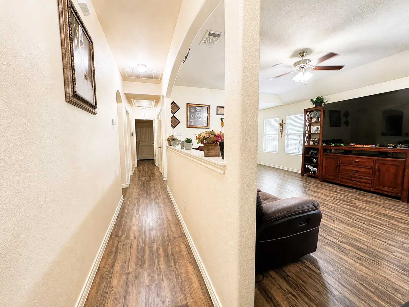 Wood-finish flooring extends throughout, complemented by arched doorways and a half-wall partition