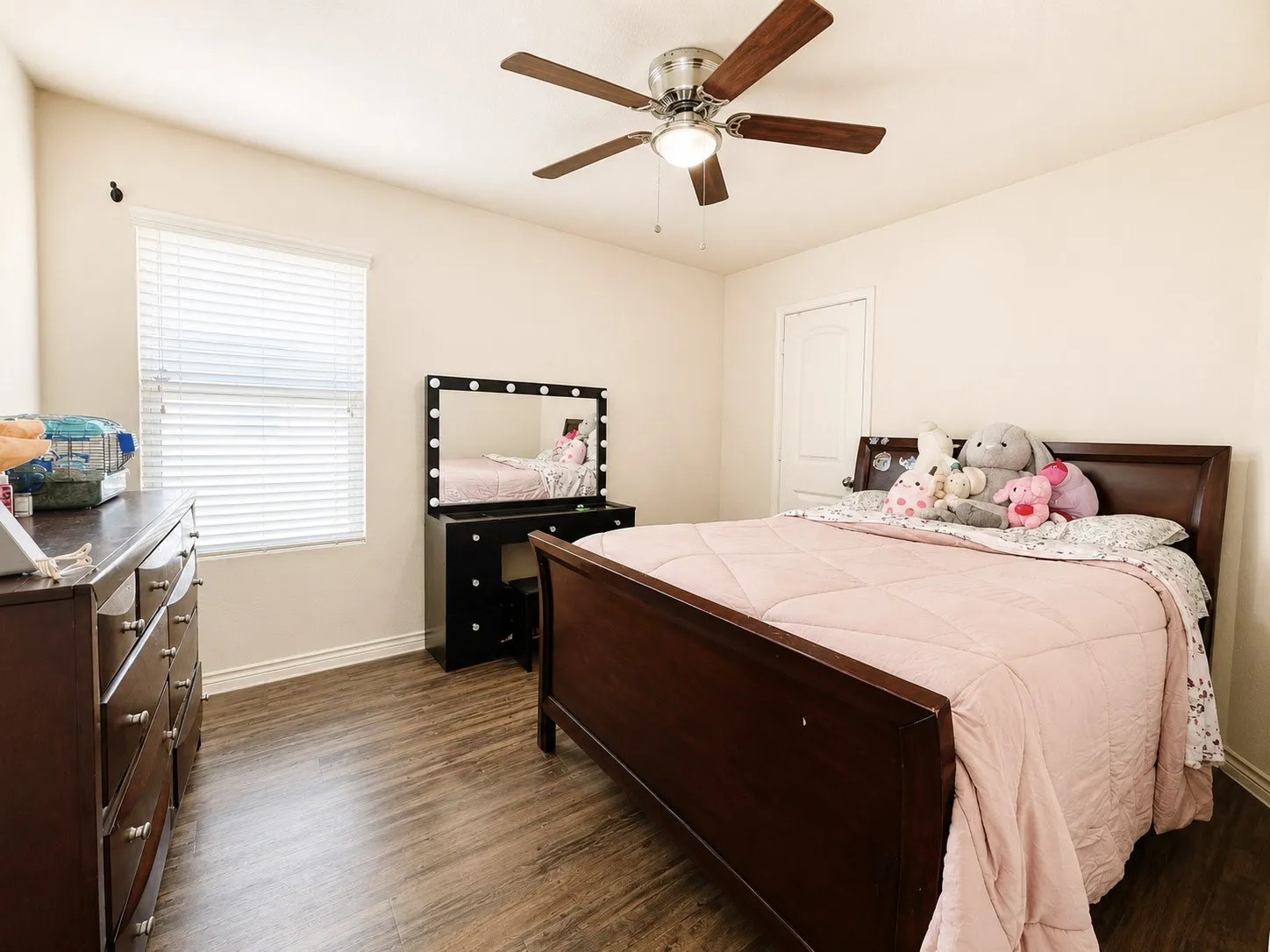 Wood-finish flooring throughout, complemented by a ceiling fan with integrated lighting