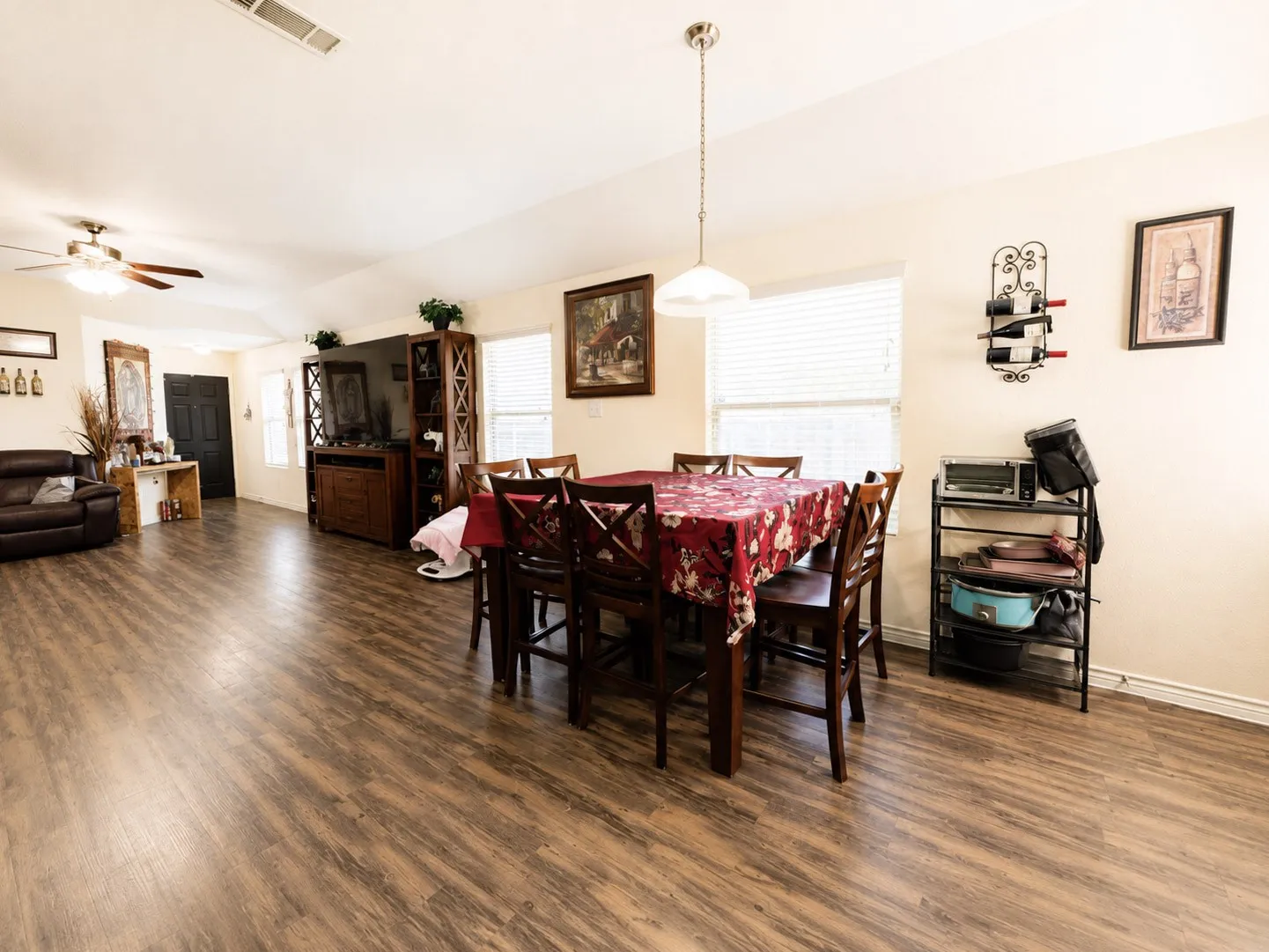 Wood-finish flooring throughout, vaulted ceiling, and multiple windows with blinds