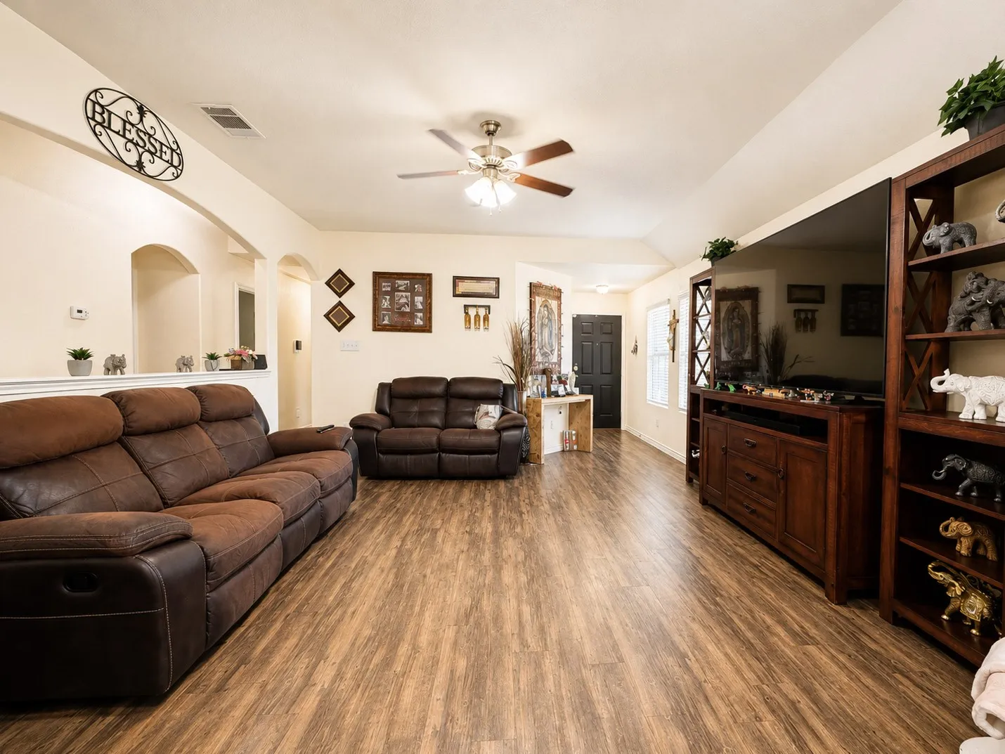 Vaulted ceiling, ceiling fan, wood-finish flooring, arched doorways, built-in shelving