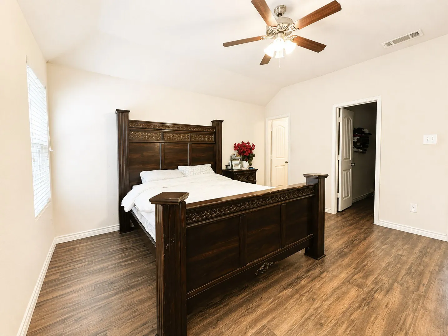 Vaulted ceiling, wood-finish flooring, ceiling fan with integrated lighting, window with blinds, and white interior doors