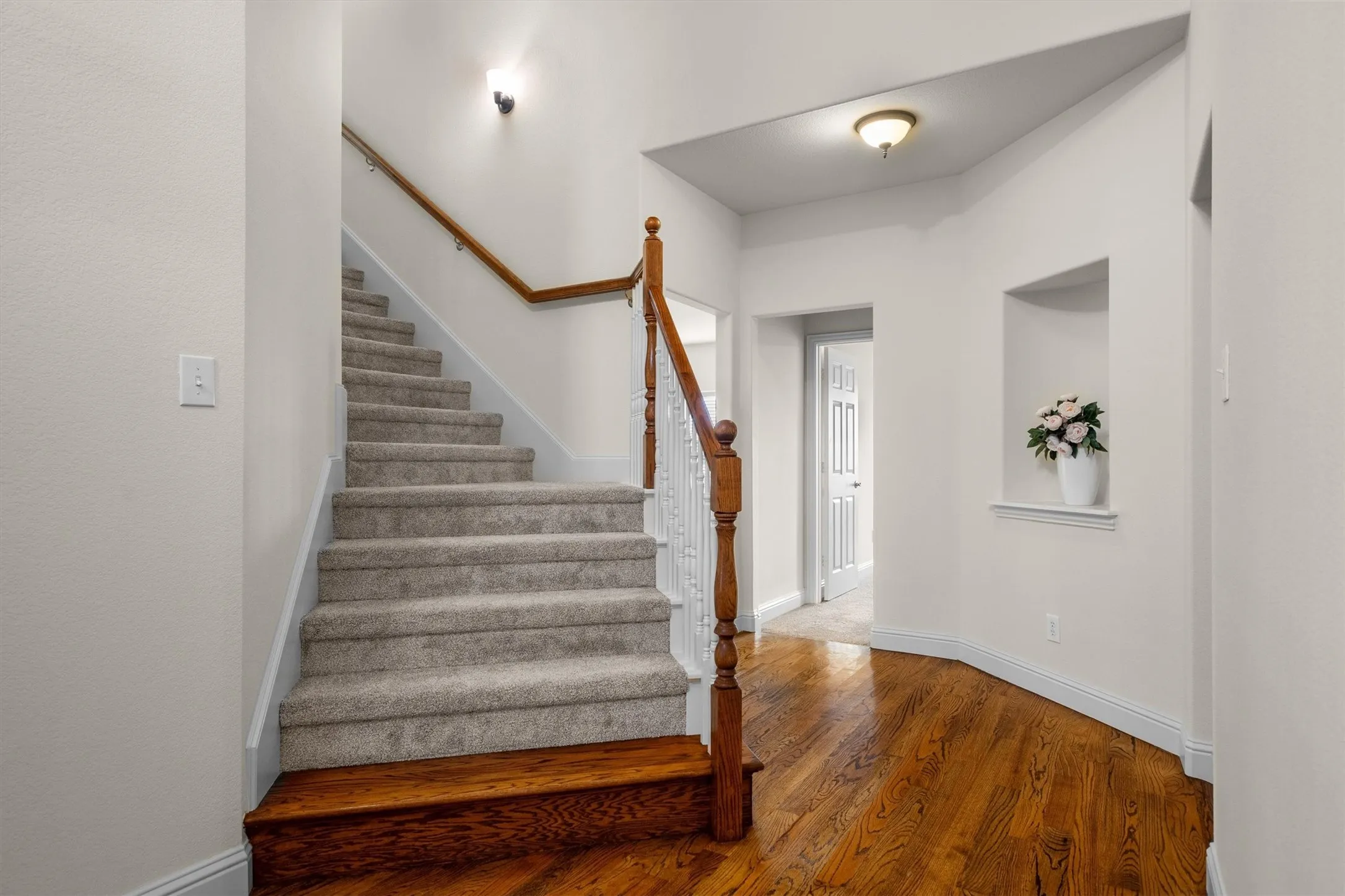 Elegant entry hallway with staircase and rich wood flooring