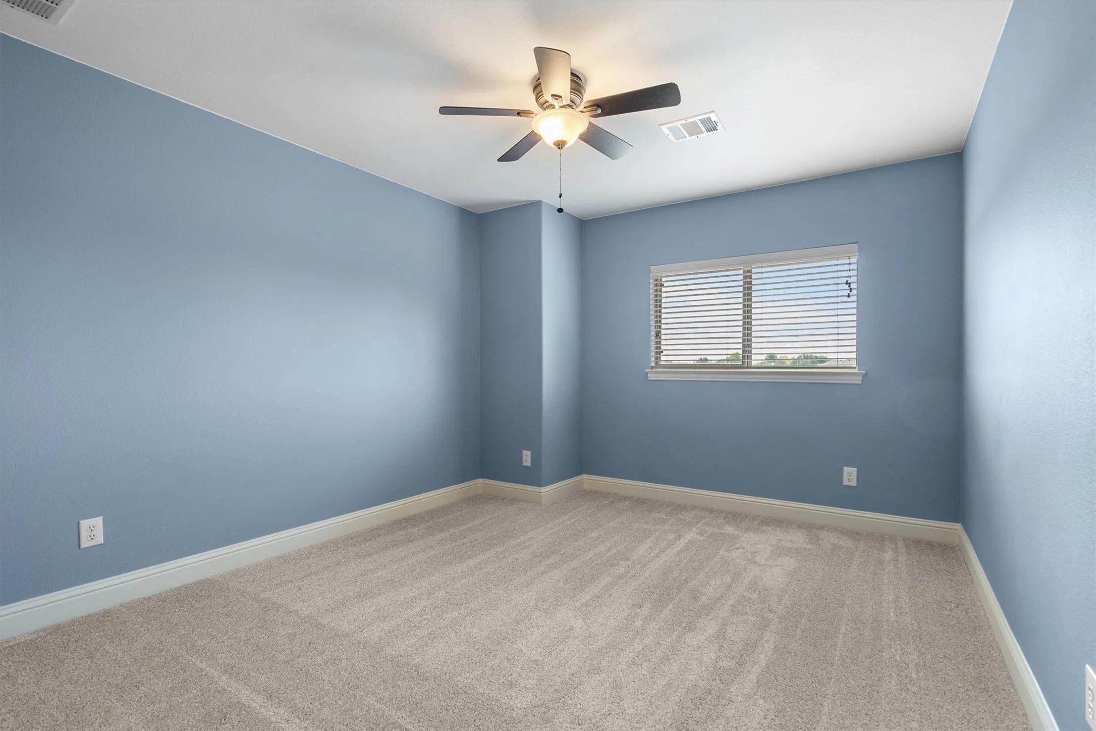 Secondary bedroom with ceiling fan and window views
