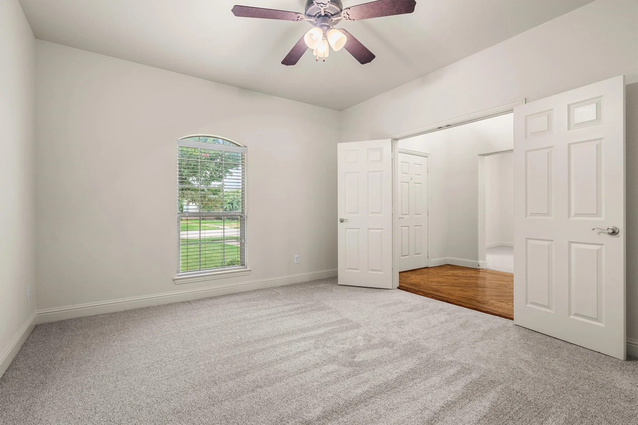 Bright flex room with ceiling fan and French doors — ideal home office or study