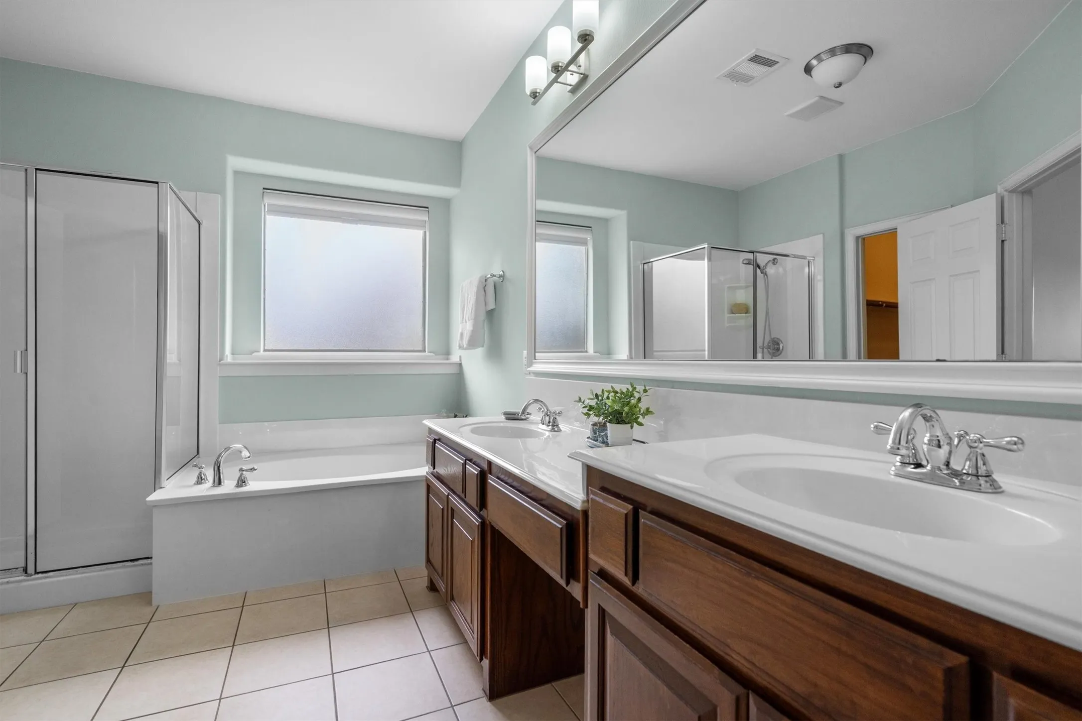 Spa-inspired bath with soaking tub, separate glass shower, and dual vanity