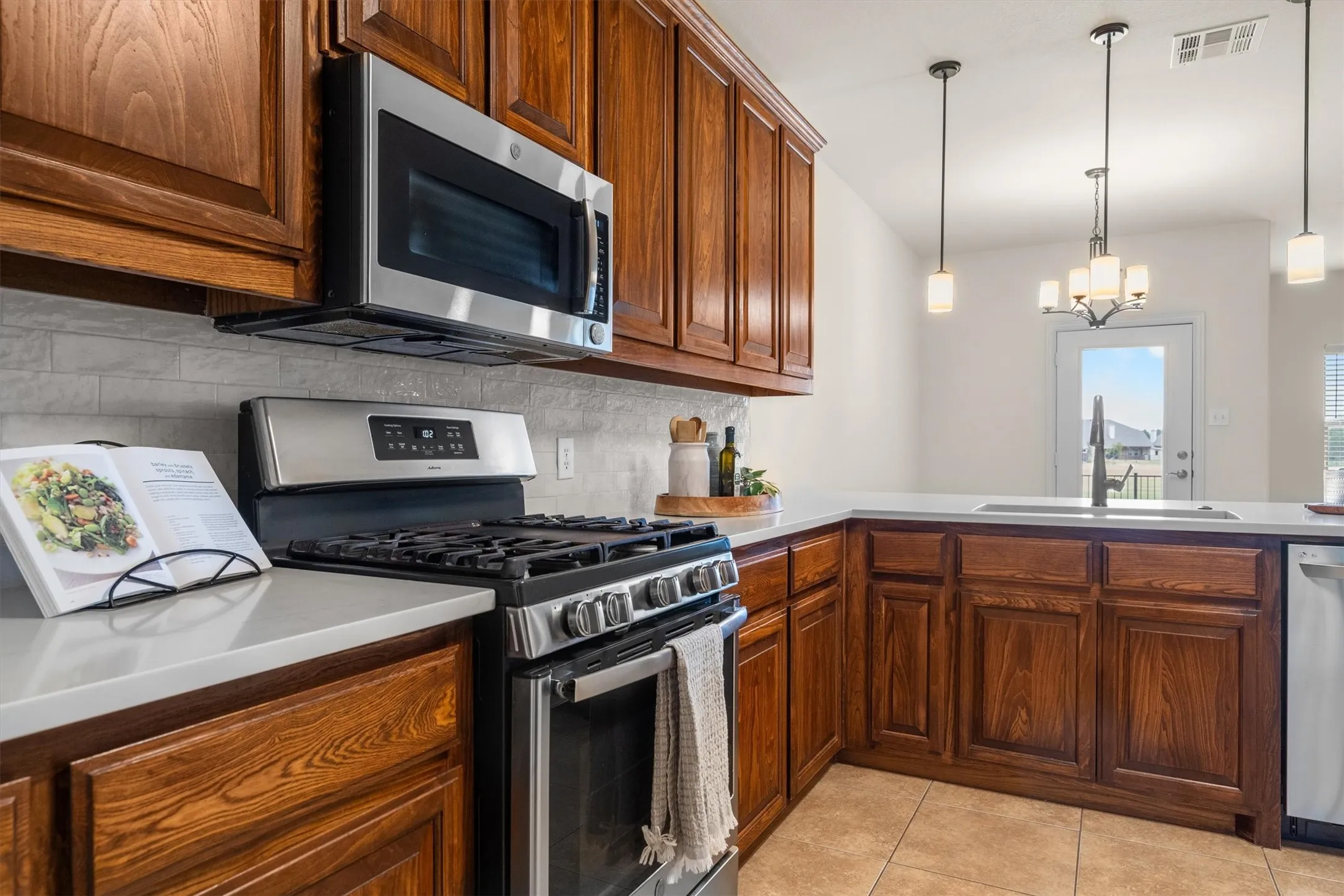 Kitchen featuring built-in microwave, gas range, and bright natural light