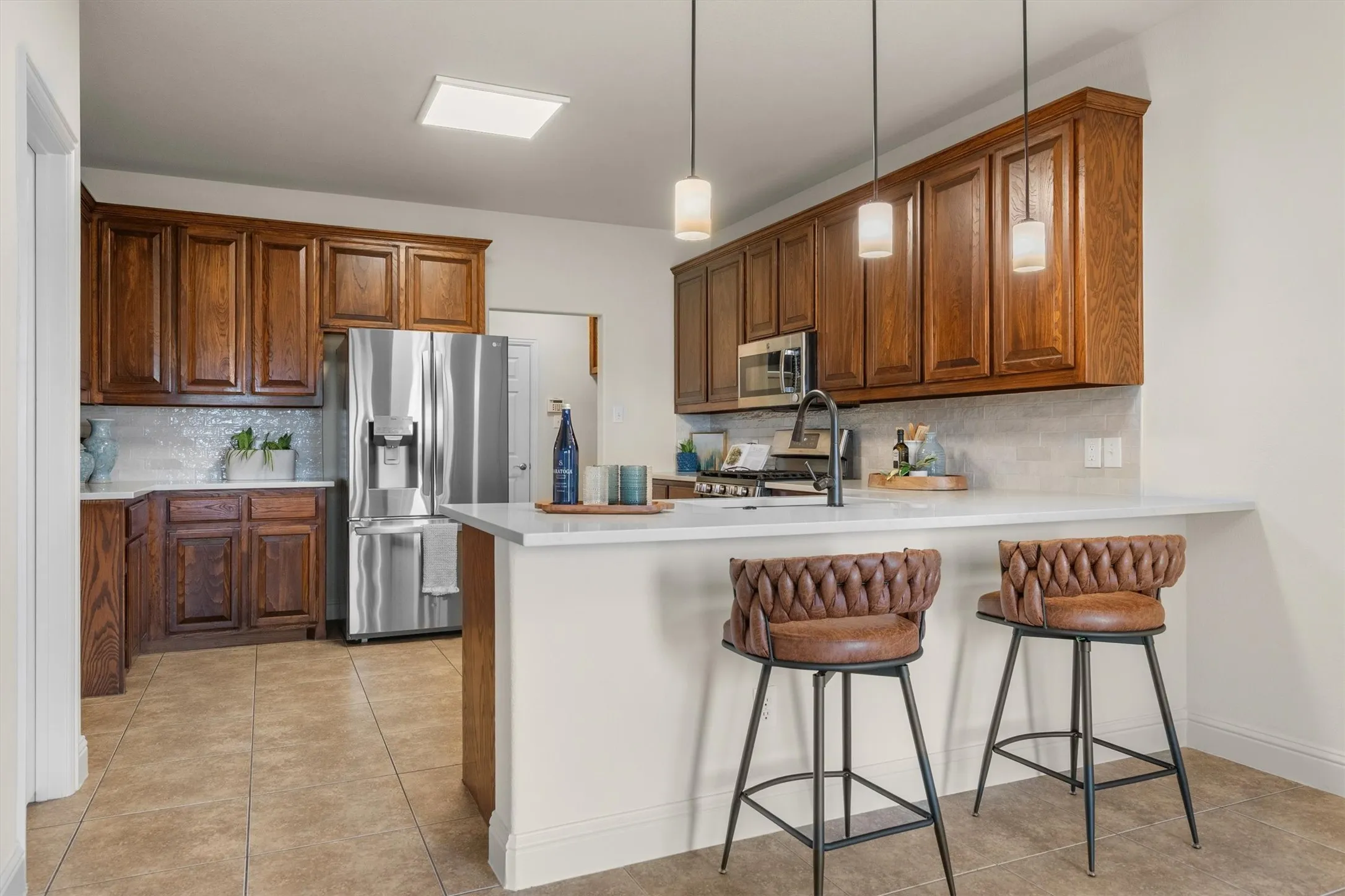 Kitchen view highlighting bar-top seating and pendant lighting