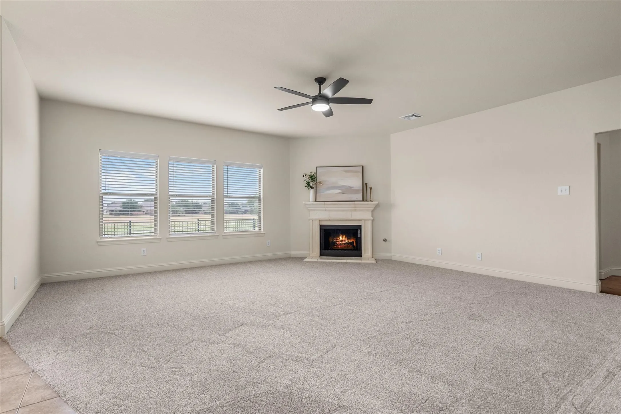 Spacious living room with cozy fireplace and a wall of windows