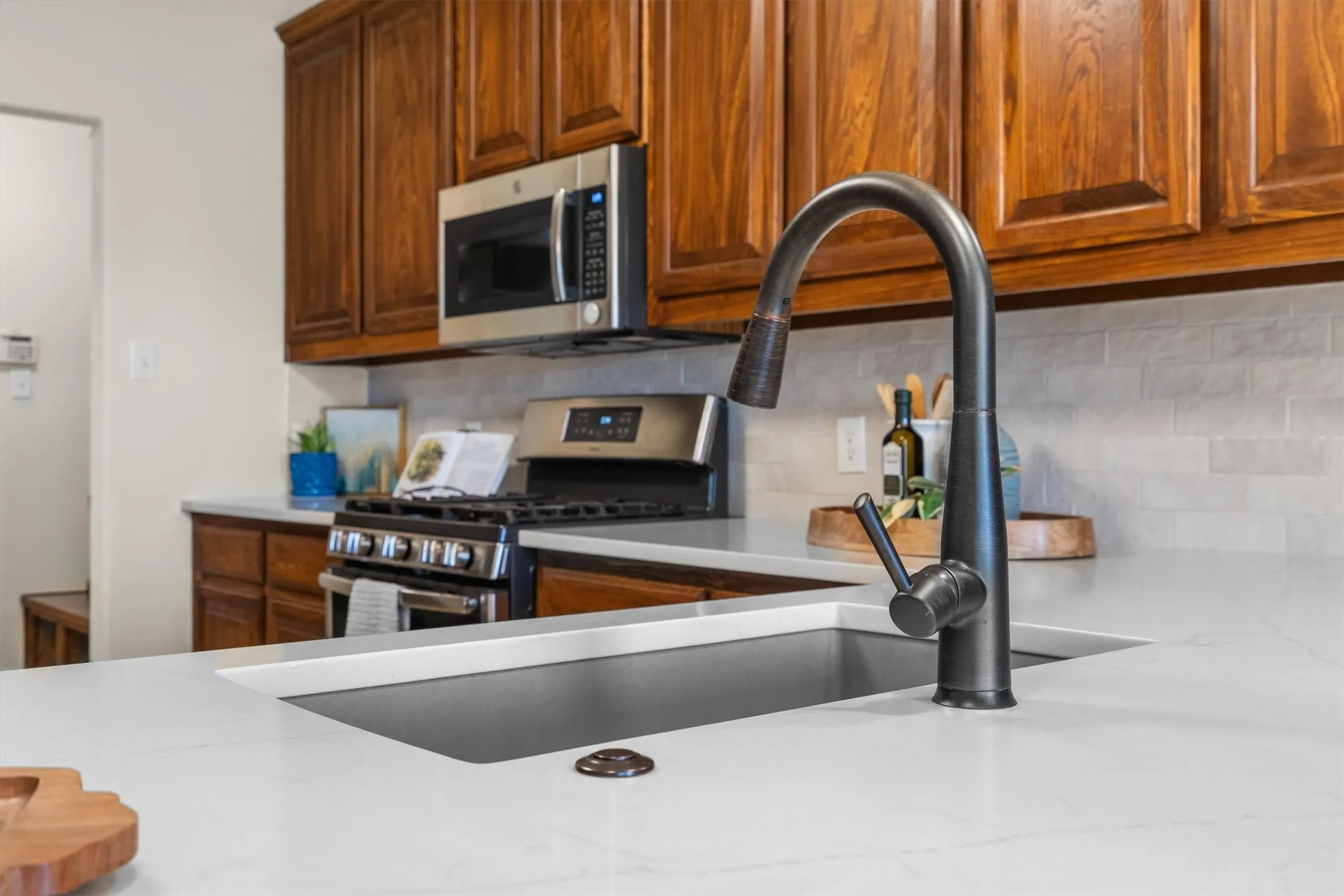 Chef-inspired kitchen detail: gas range, apron sink, and bronze fixtures