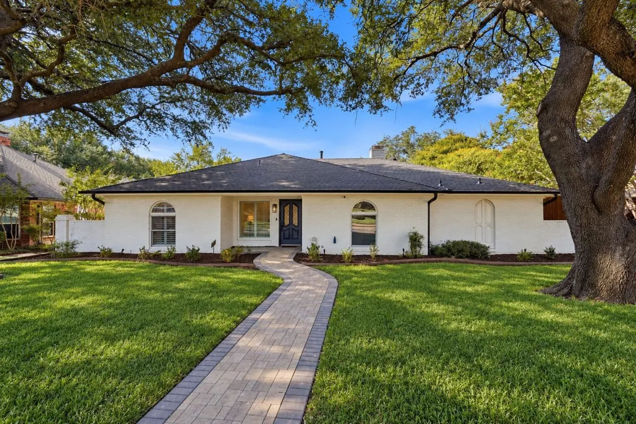 Single-story residence featuring a dark shingle roof and white exterior