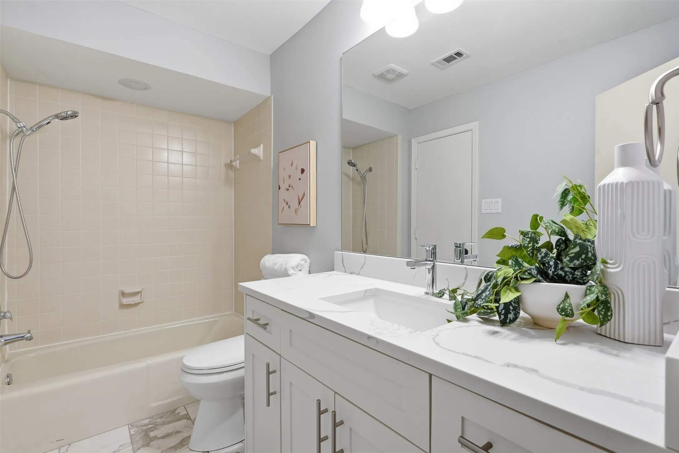 Freestanding white soaking tub with floor-mounted matte black faucet next to window with roman shade
