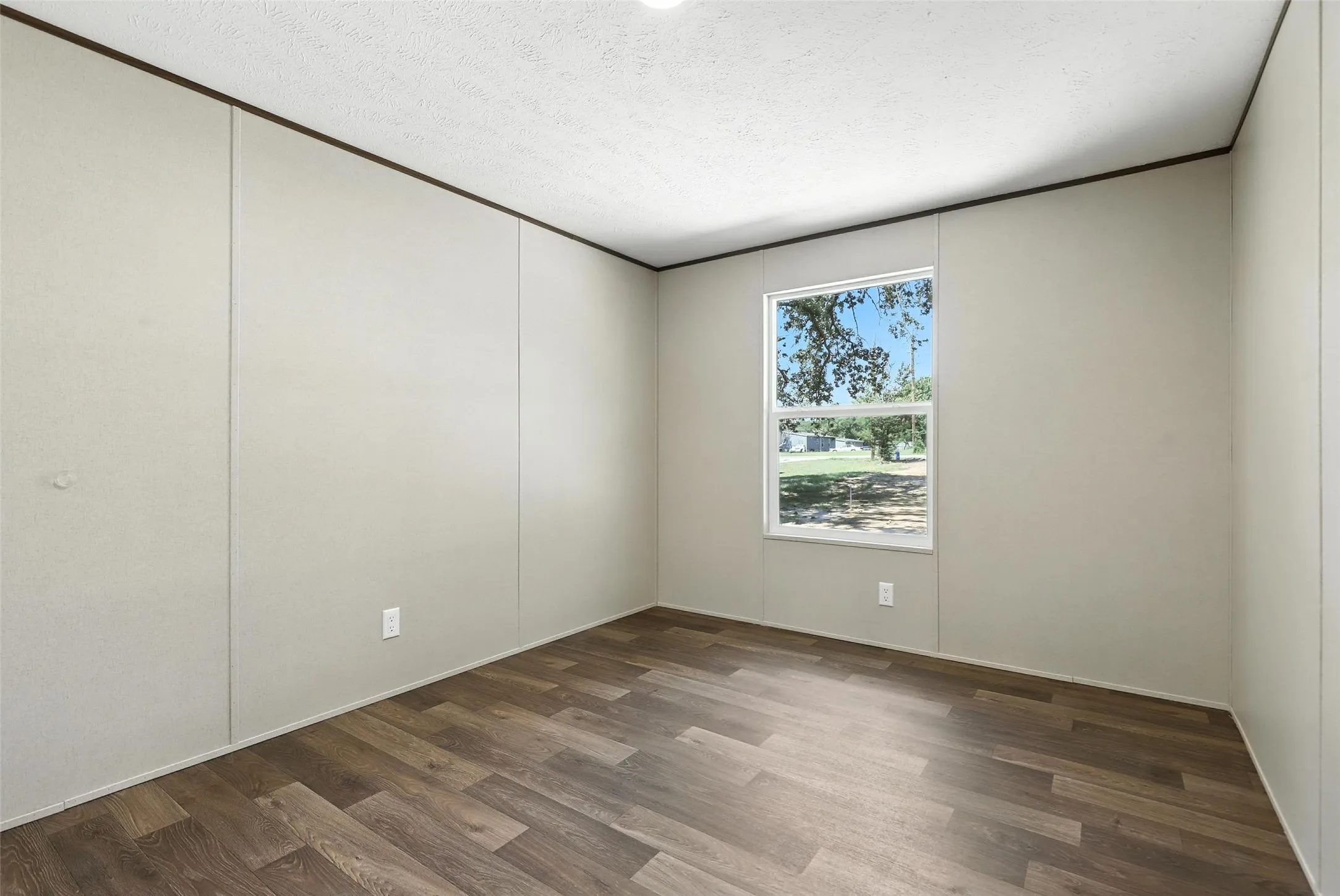 Wood-finish flooring with neutral wall panels and a single window