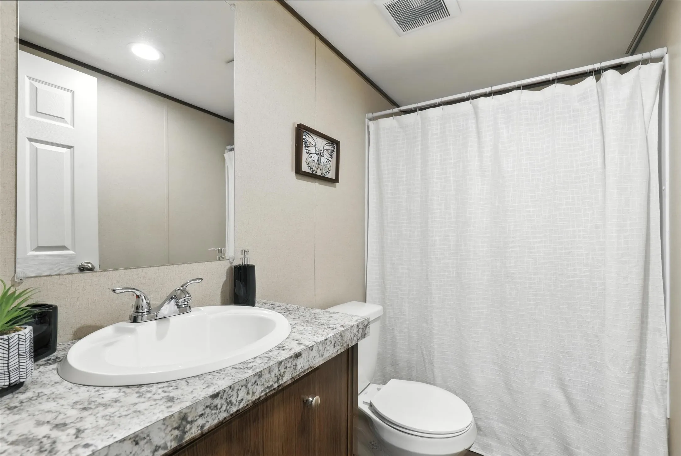 Vanity with chrome faucet, integrated sink, and wood-finish cabinetry