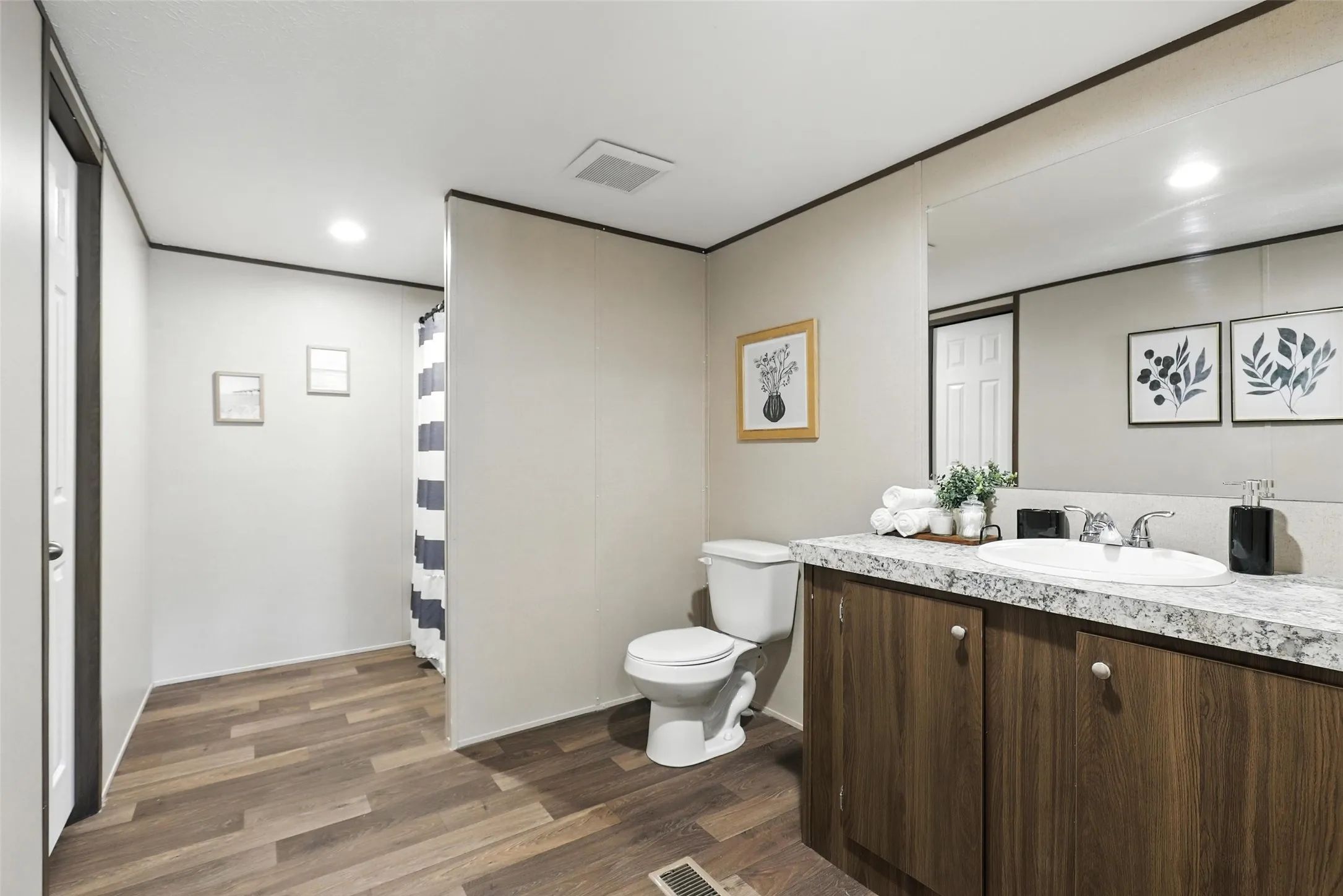 Bathroom featuring wood-finish flooring, a vanity with a light-colored countertop, and an integrated sink