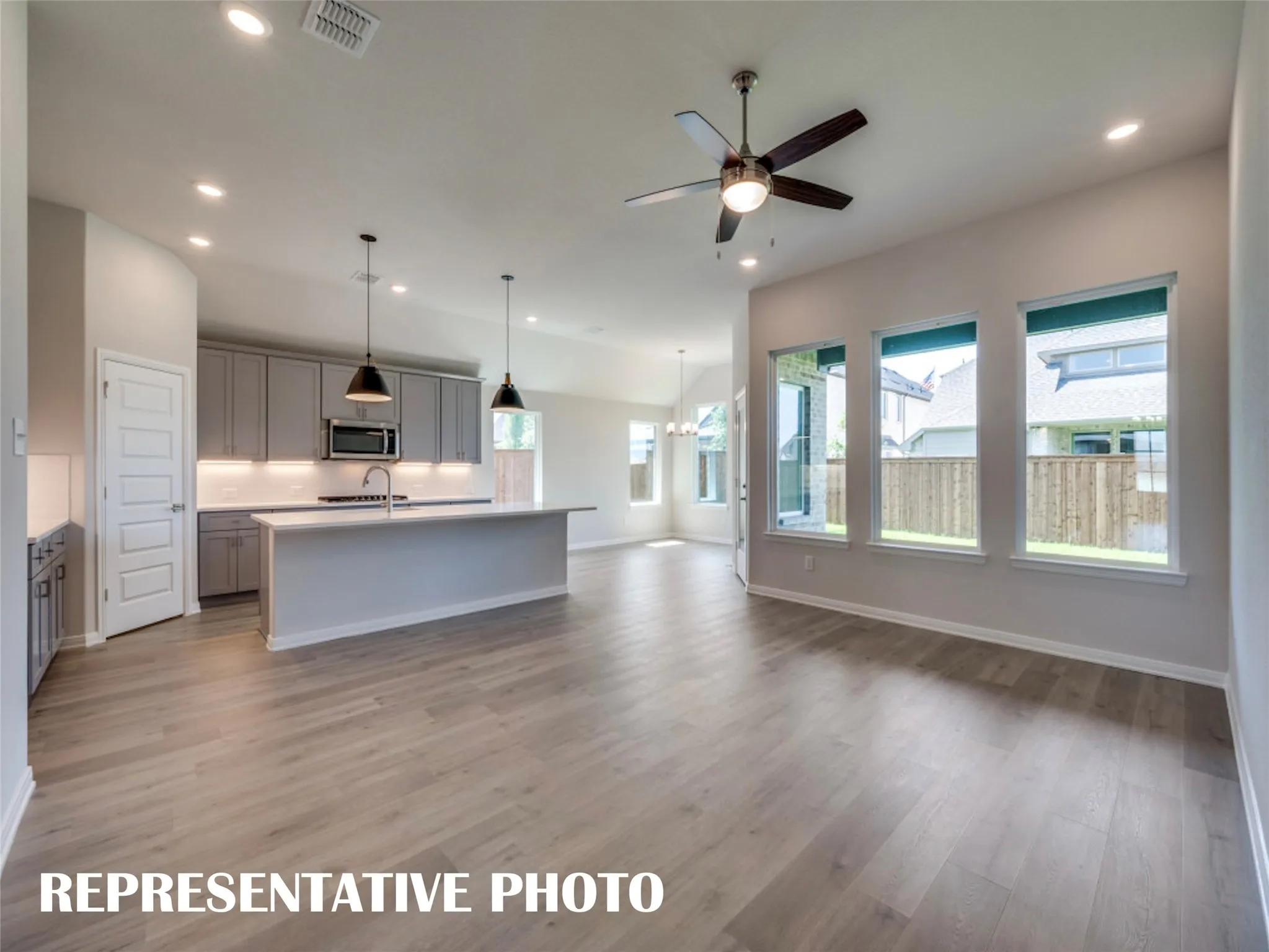 The open concept design of this wonderful home features beautiful flooring, walls of windows, a dream kitchen and so much more!  REPRESENTATIVE PHOTO